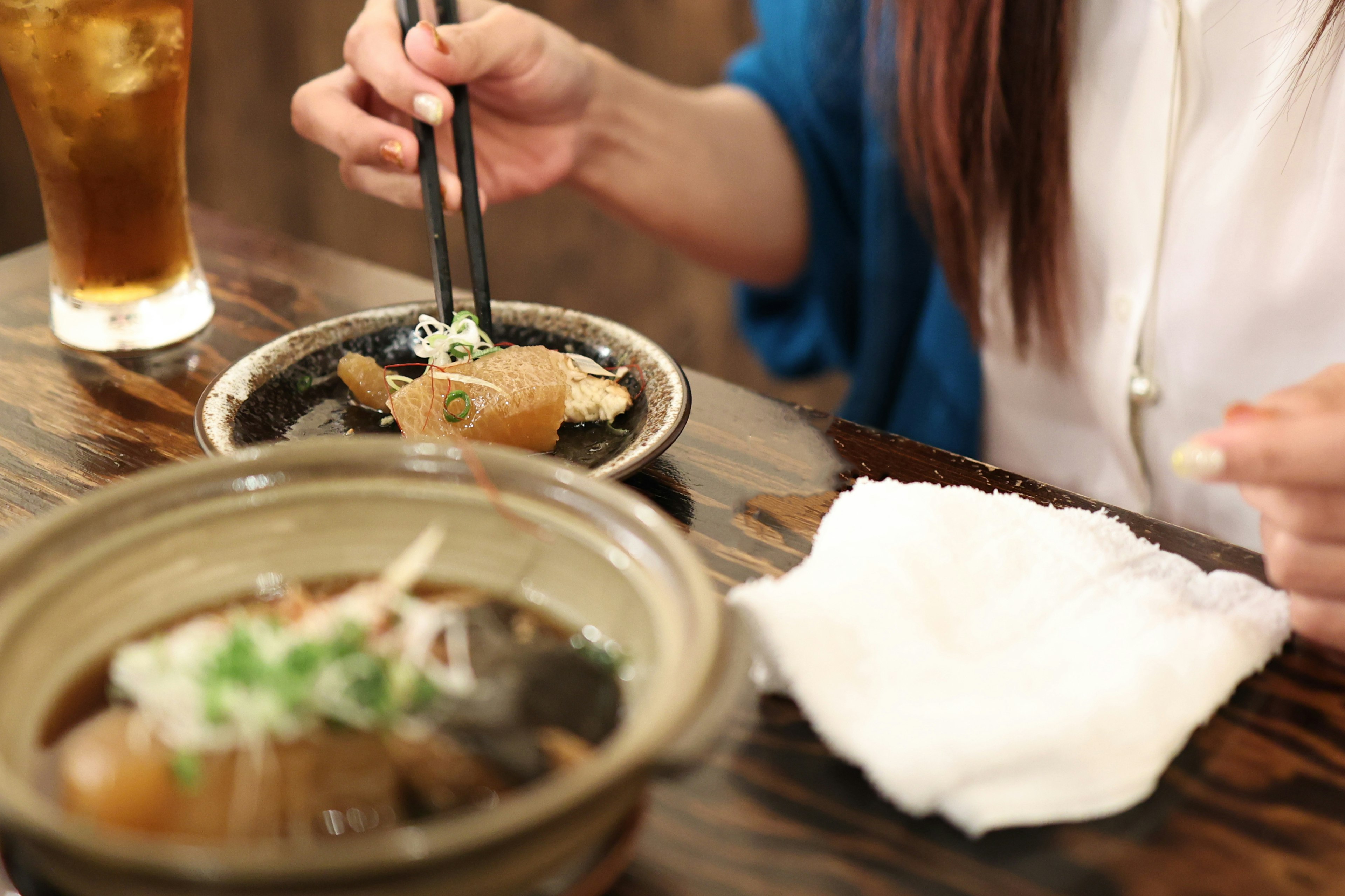 A woman enjoying a meal using chopsticks to pick food