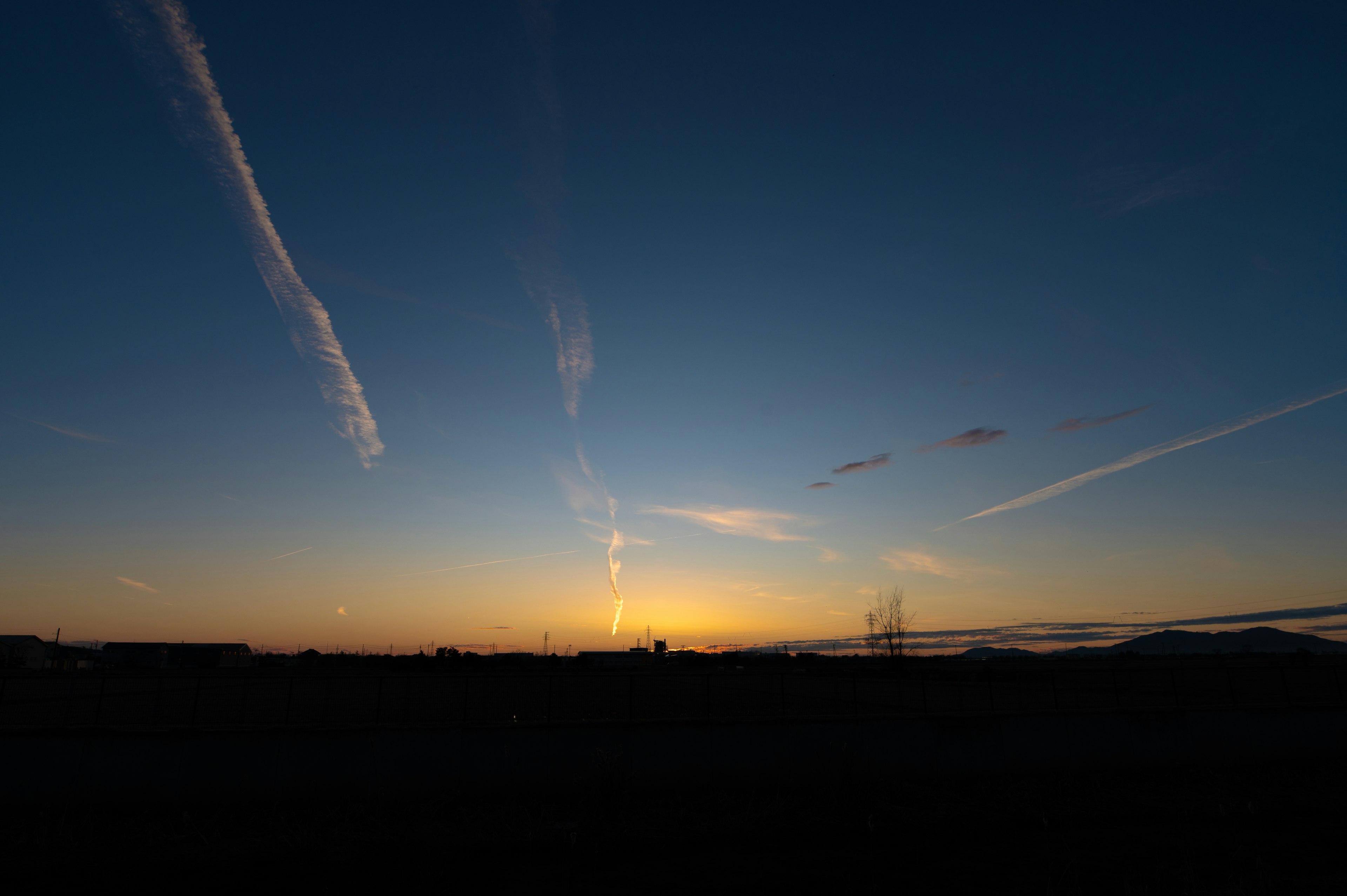 Ciel de coucher de soleil avec des traînées de nuages et silhouette de montagnes