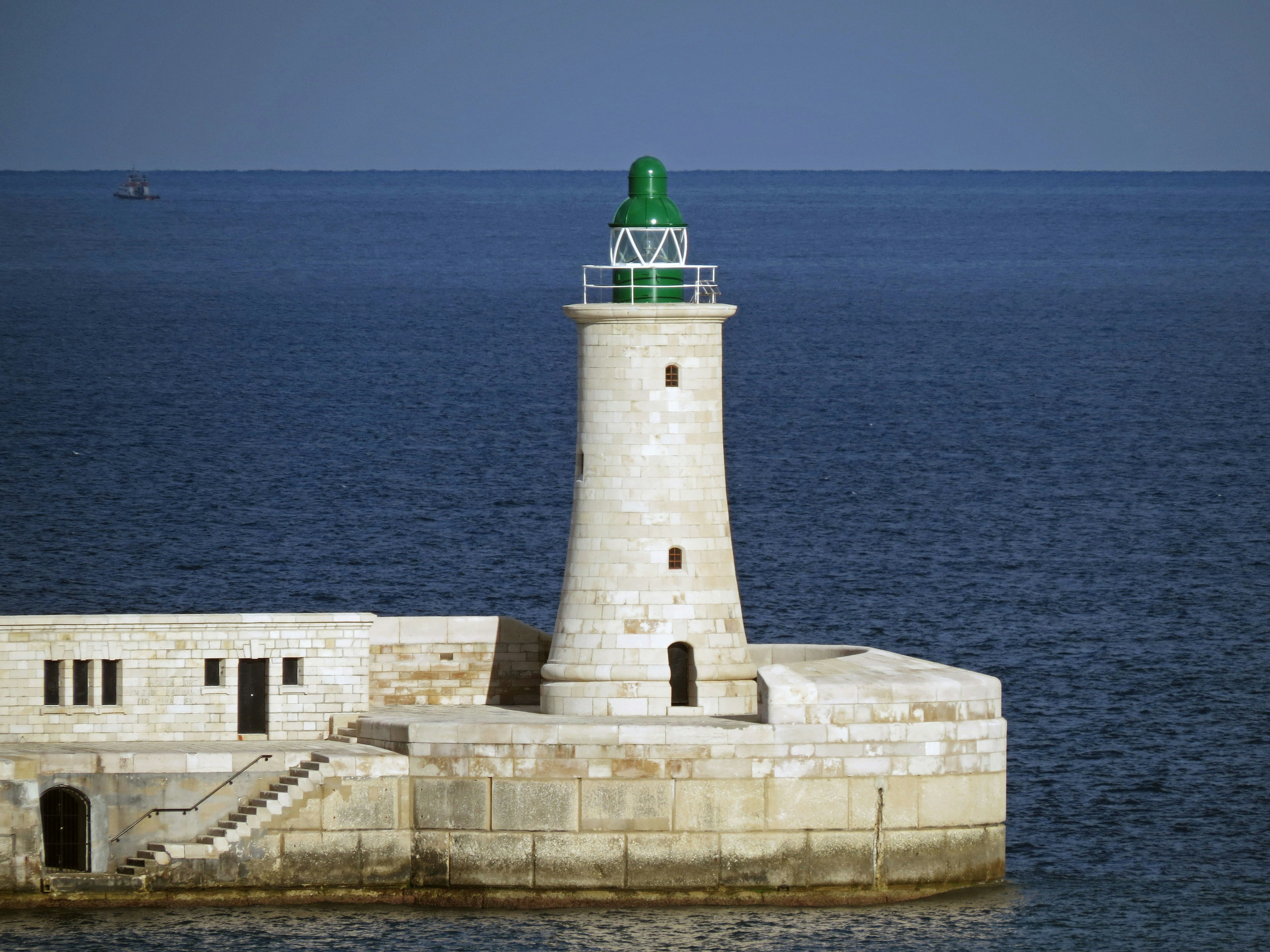 Image d'un phare vert se tenant dans la mer bleue