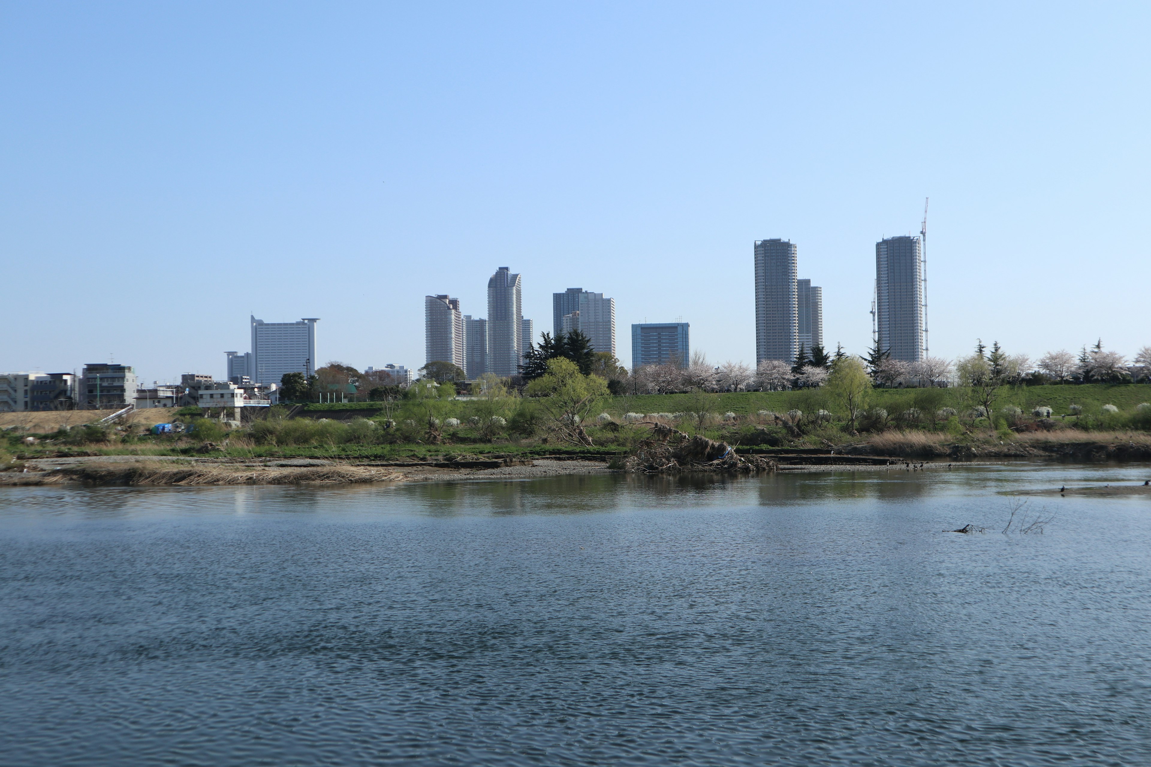 Ligne d'horizon de la ville sous un ciel bleu clair avec une rivière au premier plan