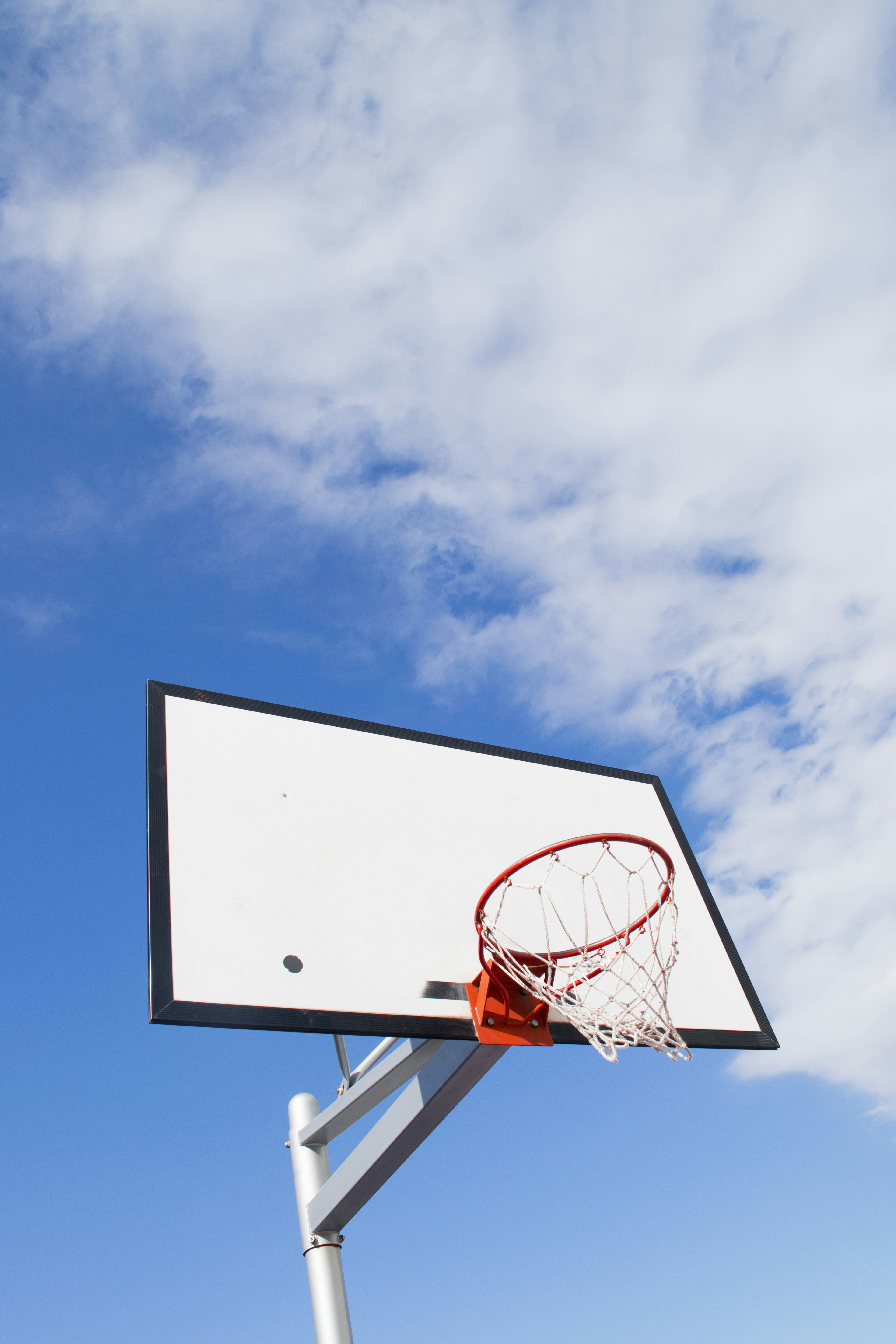 Basketballkorb und -brett unter einem blauen Himmel