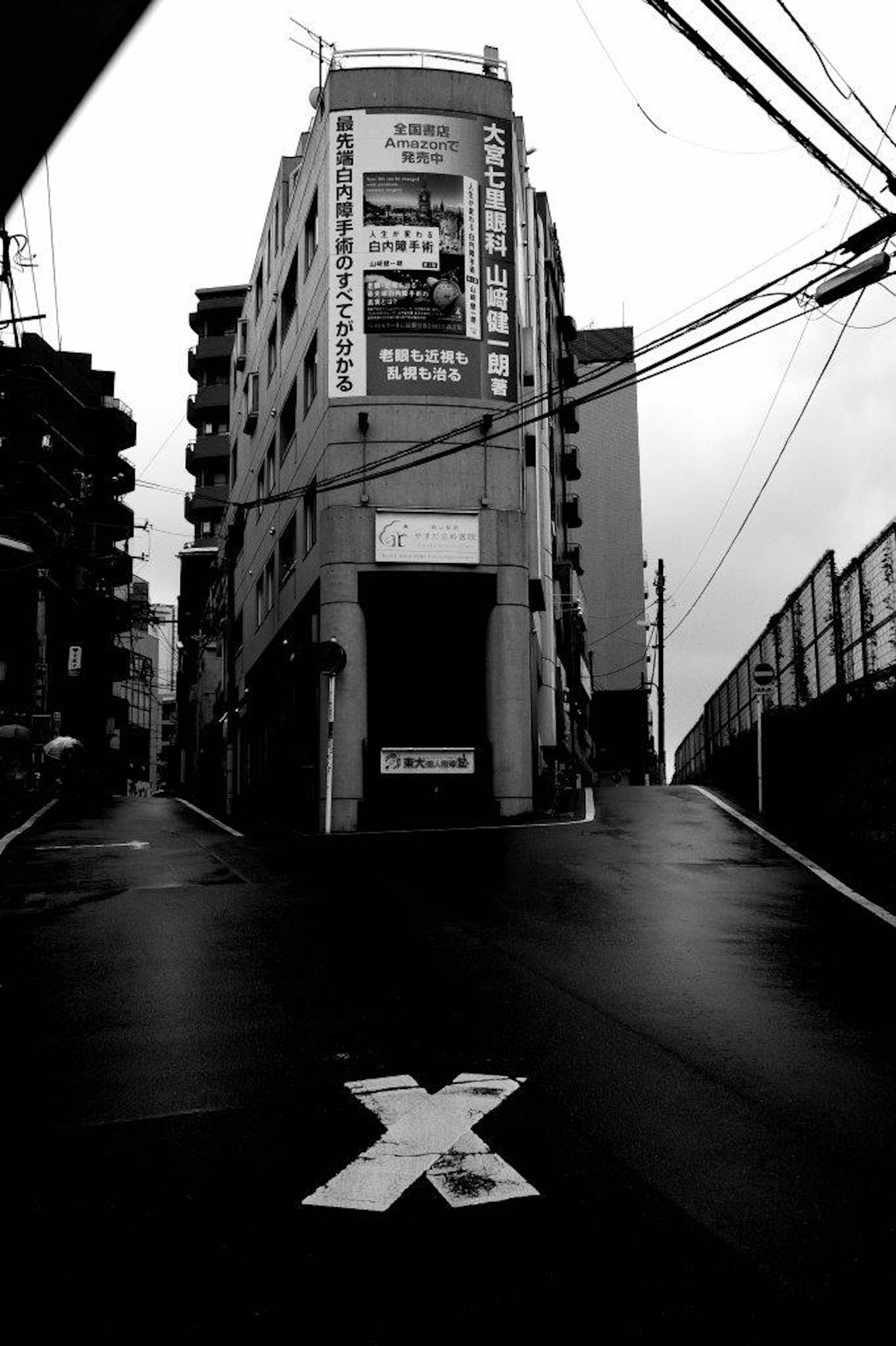 Black and white street scene Steep hill and old building Prominent X mark