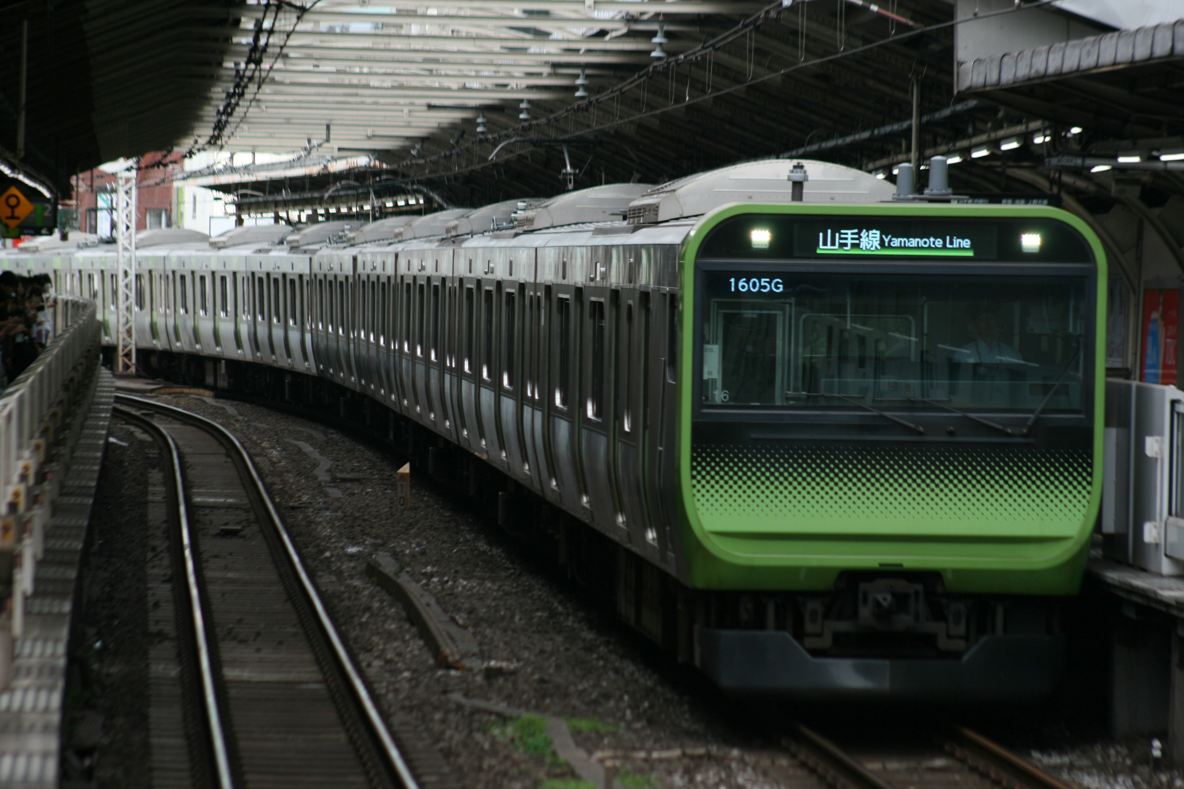 緑色の電車が駅に停車している画像