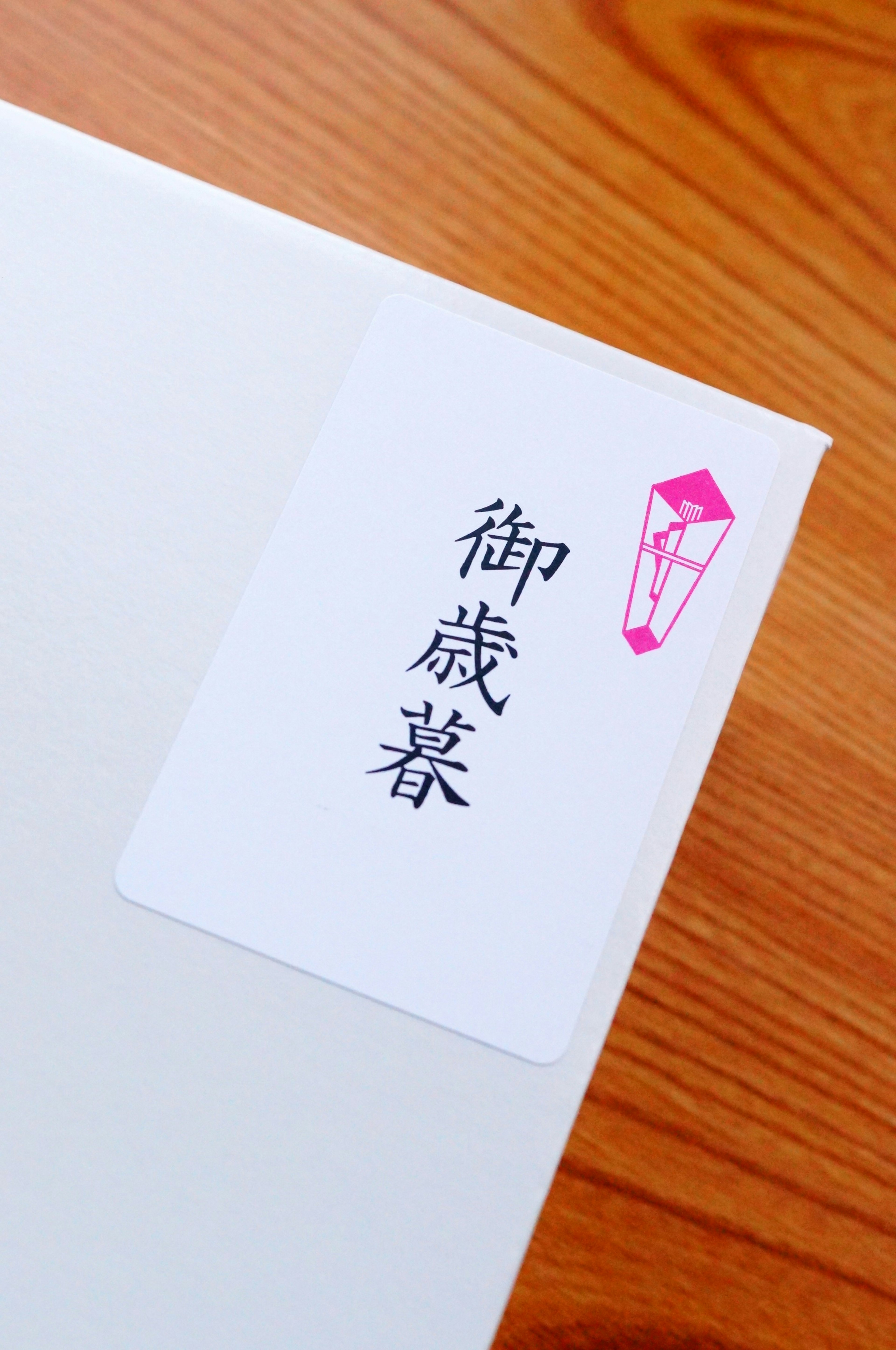 White envelope with a pink label featuring Japanese text