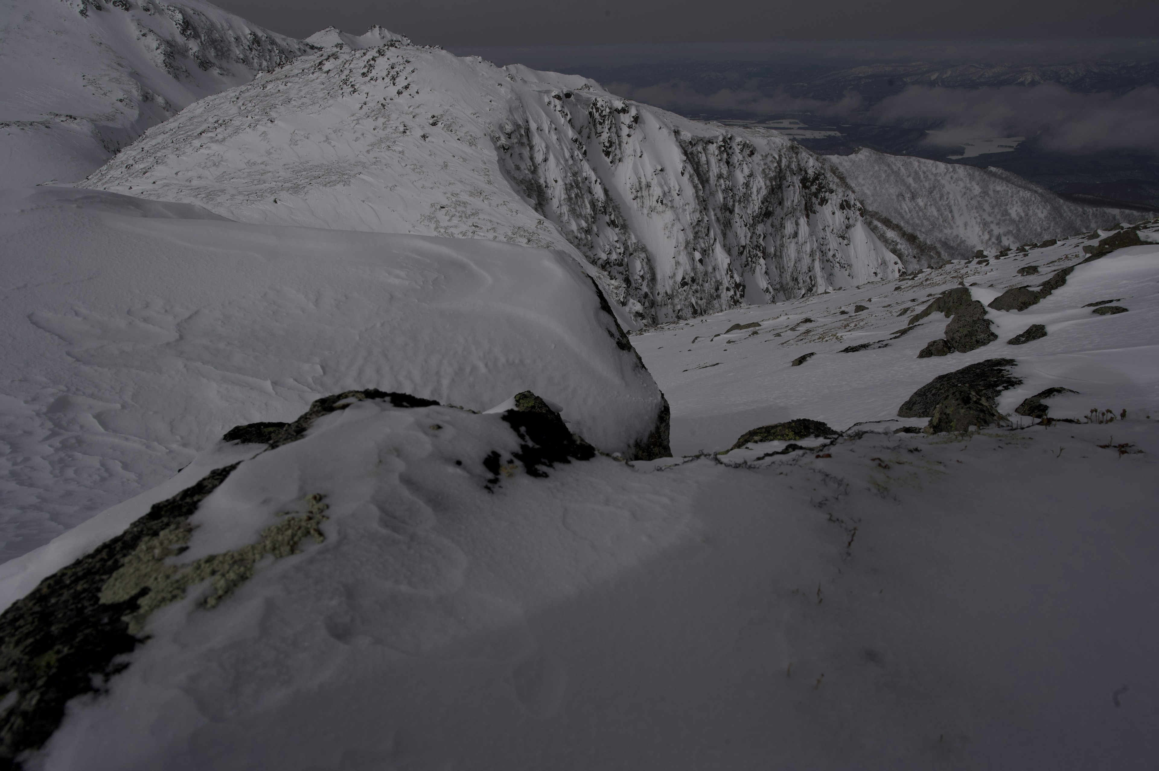 Paisaje montañoso cubierto de nieve con detalles rocosos