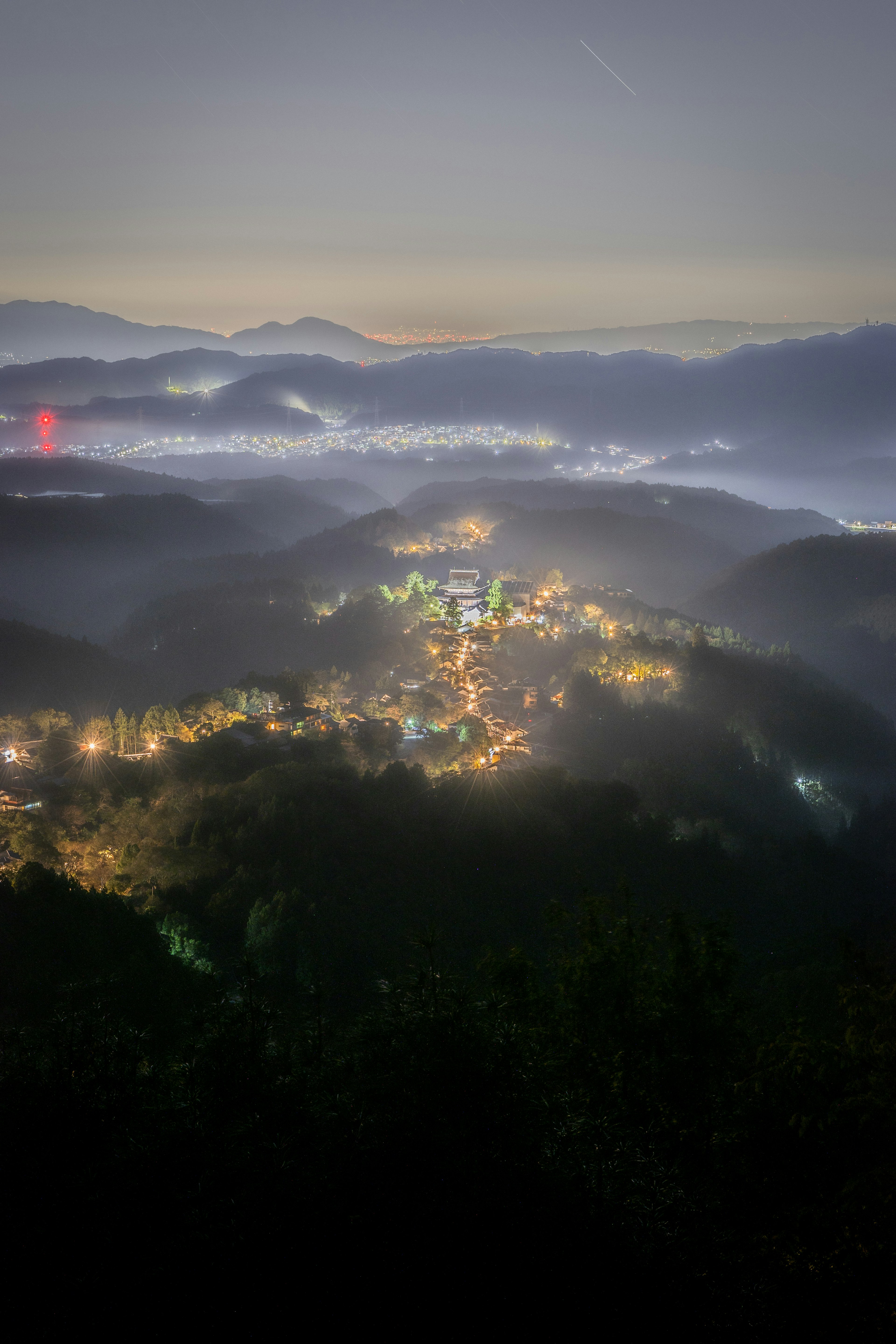 夜景の山々と霧に包まれた村の風景