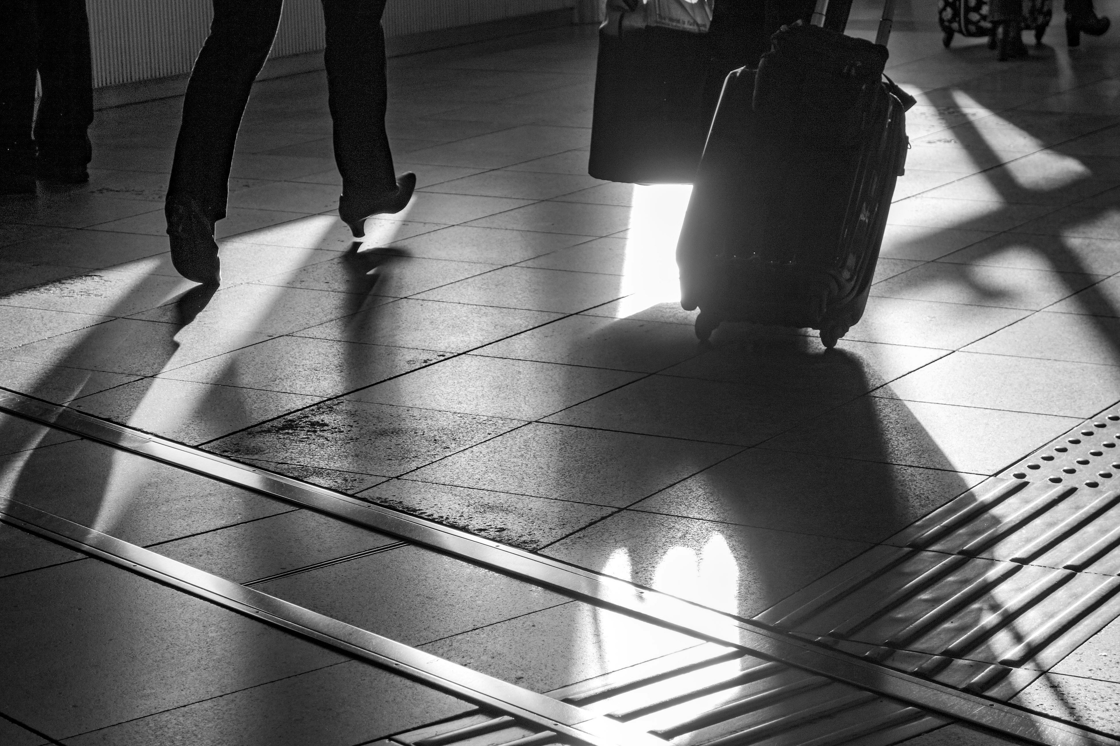 A person walking with a suitcase in an airport setting