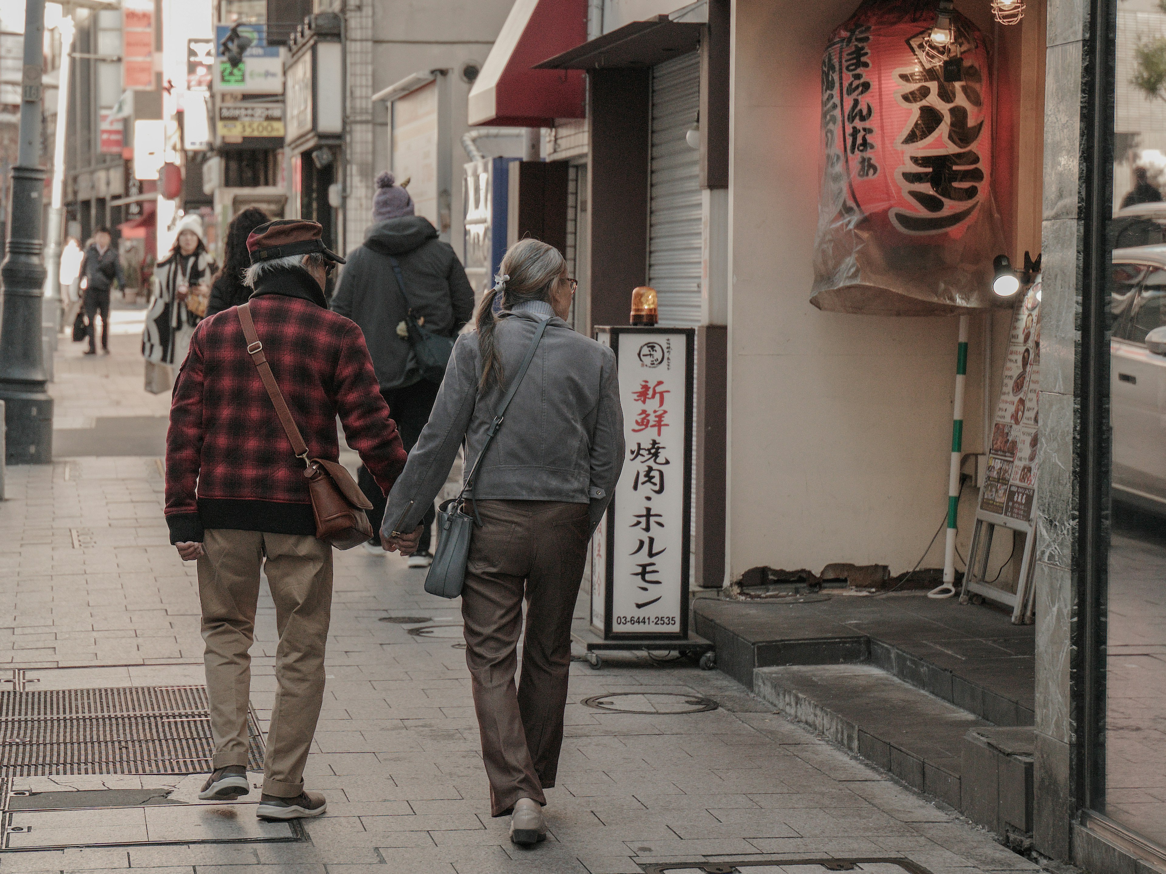 一对情侣在城市街道上手牵手散步