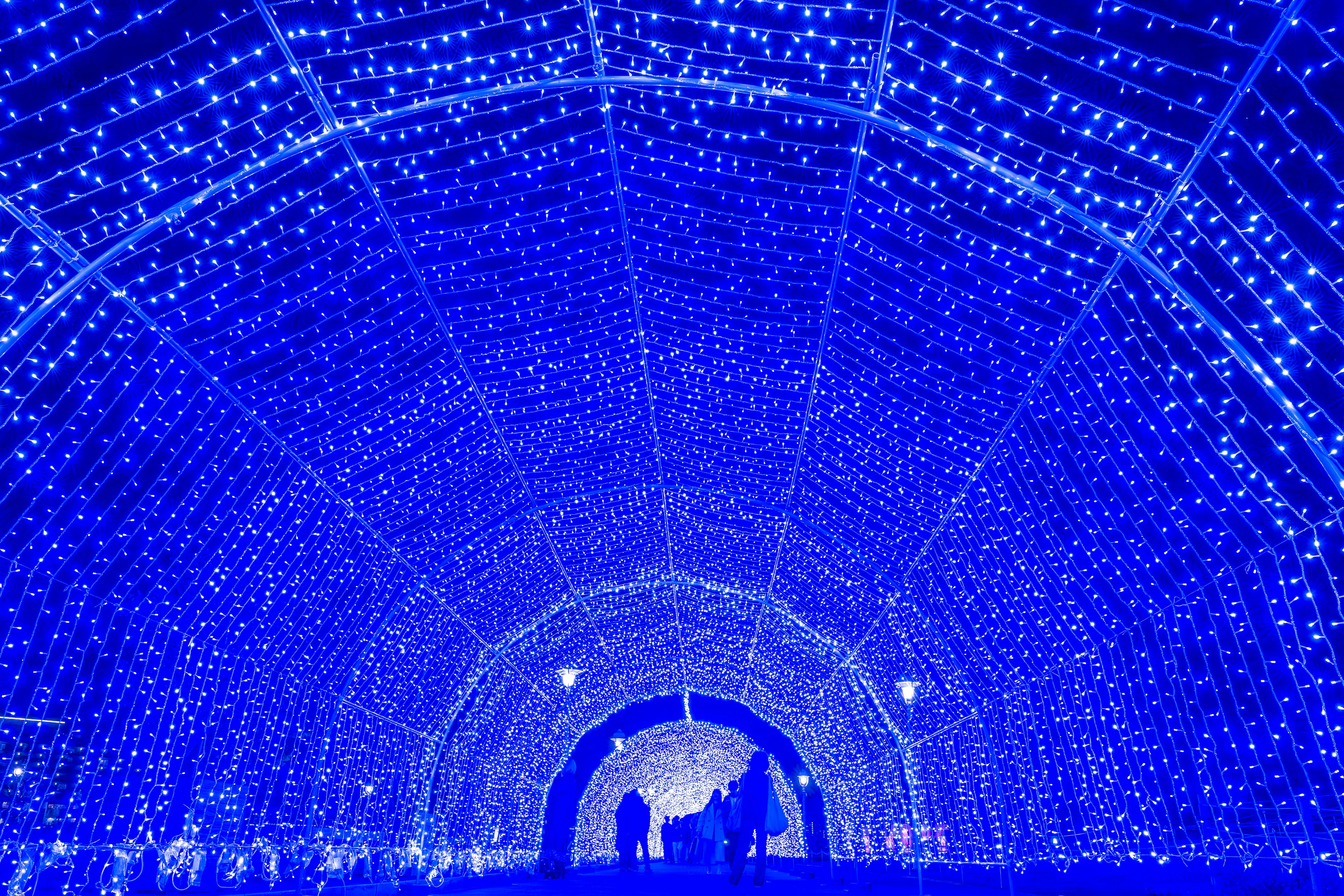 Una scena magica di persone che camminano attraverso un tunnel di luce blu