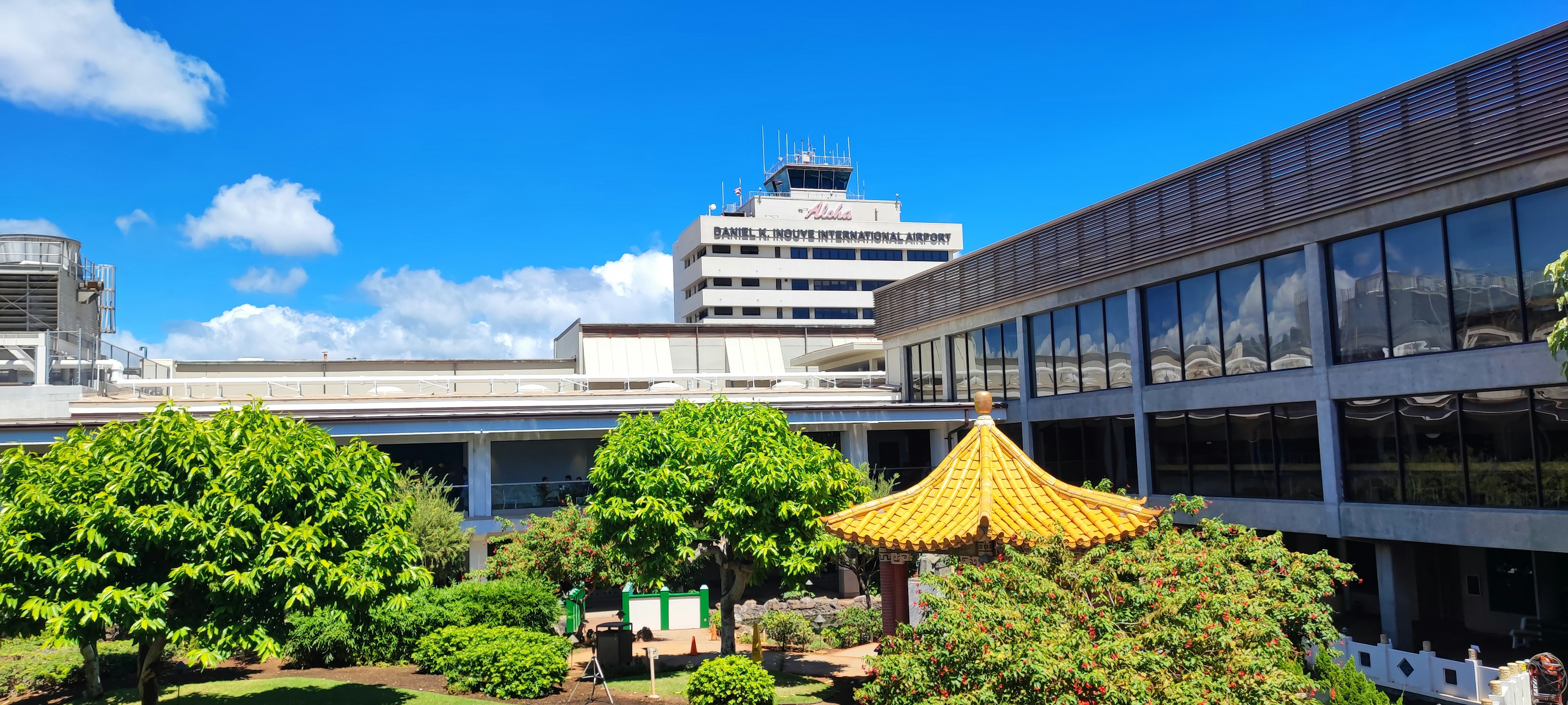 Modern building with traditional Chinese roof in a garden under blue sky