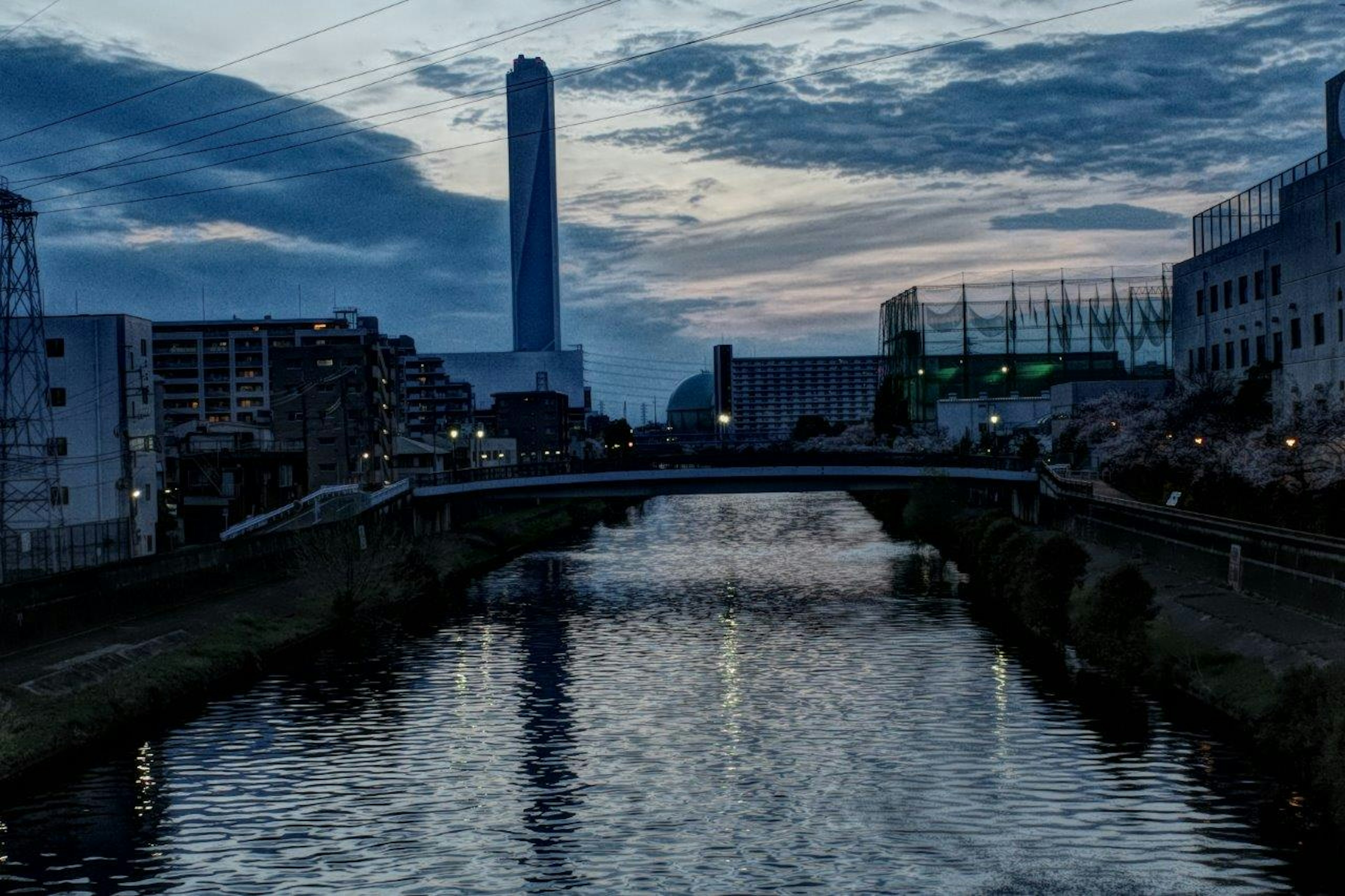 Vue au crépuscule d'une rivière et d'un pont avec un gratte-ciel en arrière-plan