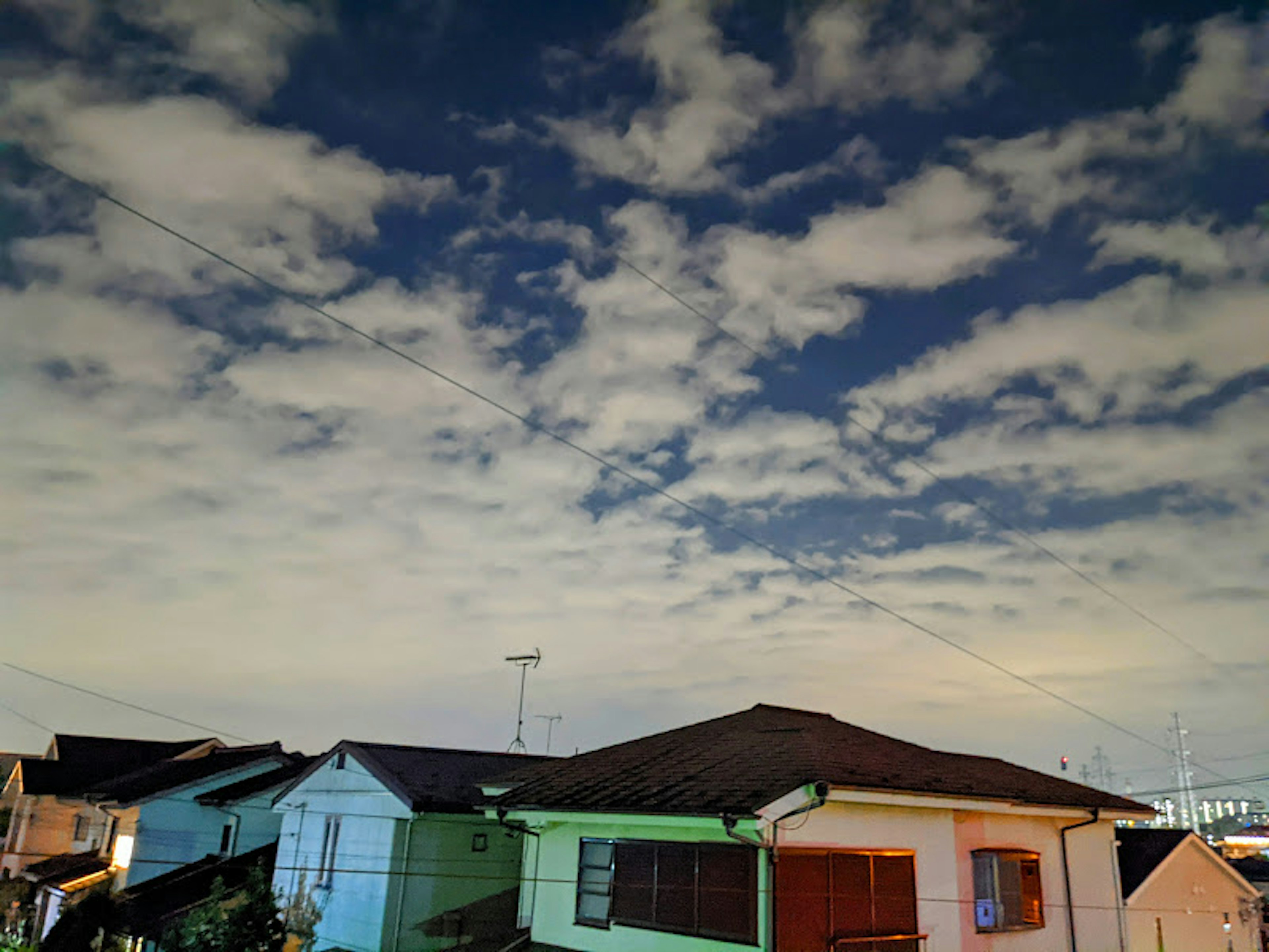 Night sky with clouds over residential houses