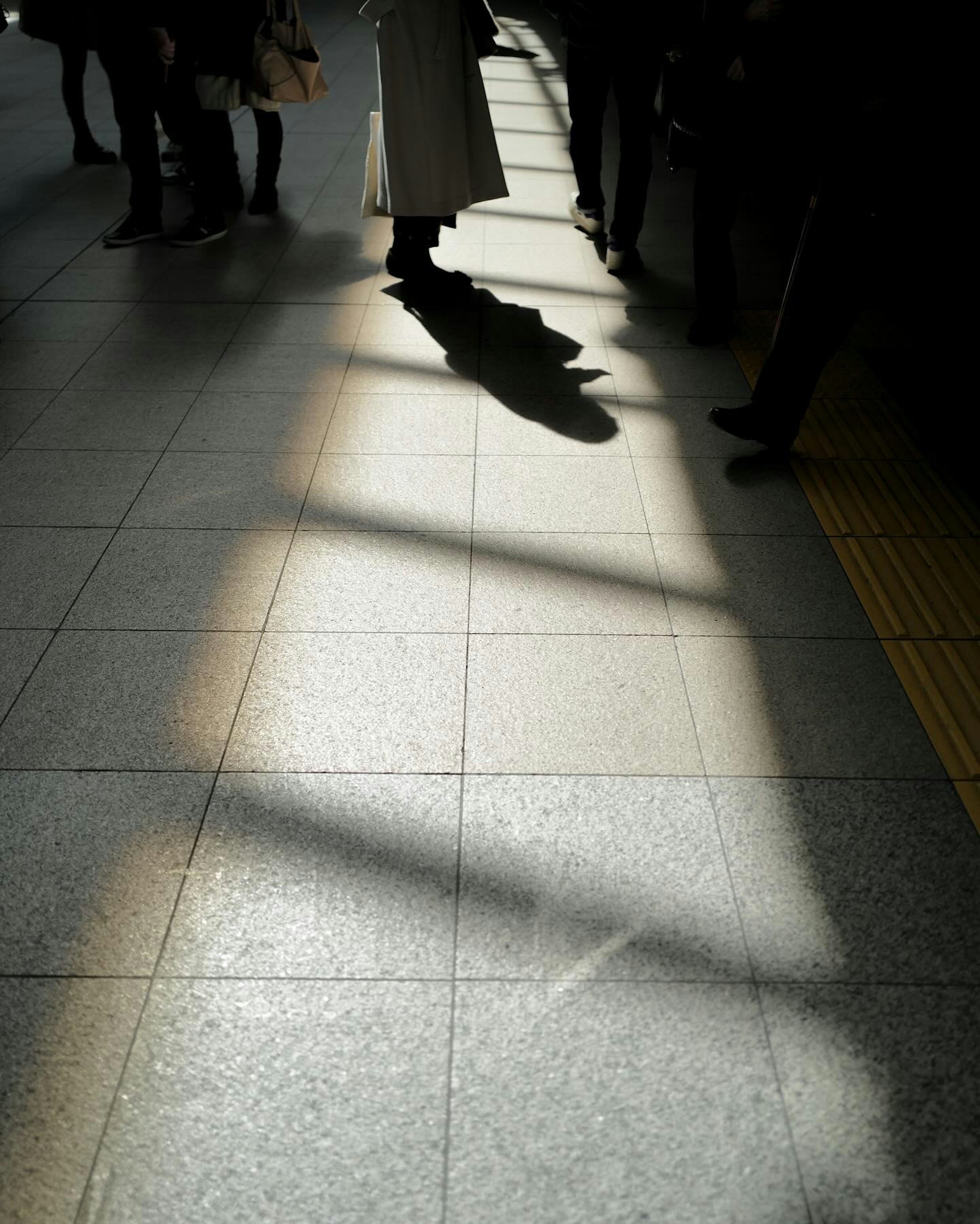 Intersection of shadows and light on a train station floor