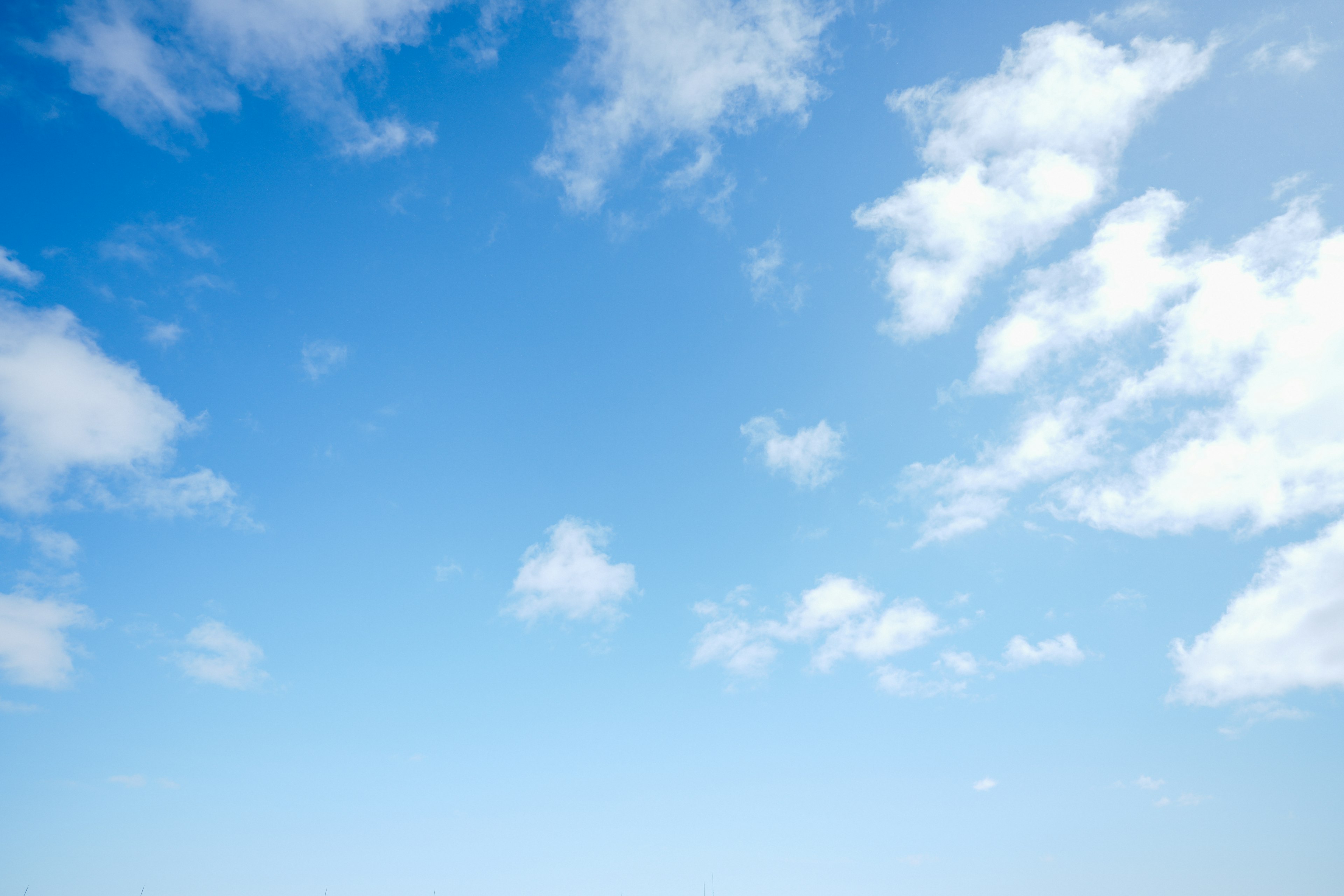 Eine Landschaft mit weißen Wolken, die in einem blauen Himmel schweben