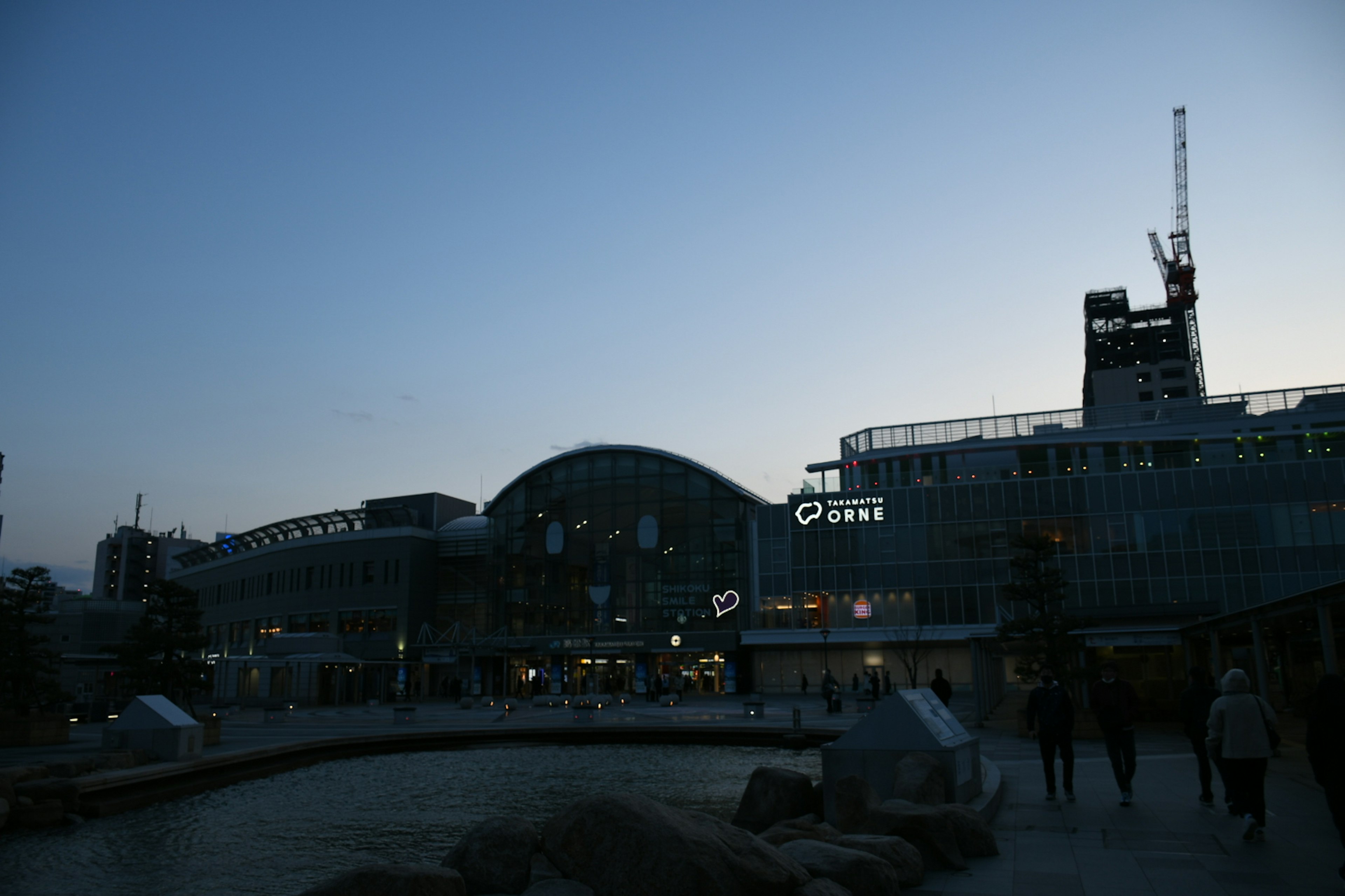 夜の駅の外観と周囲の人々