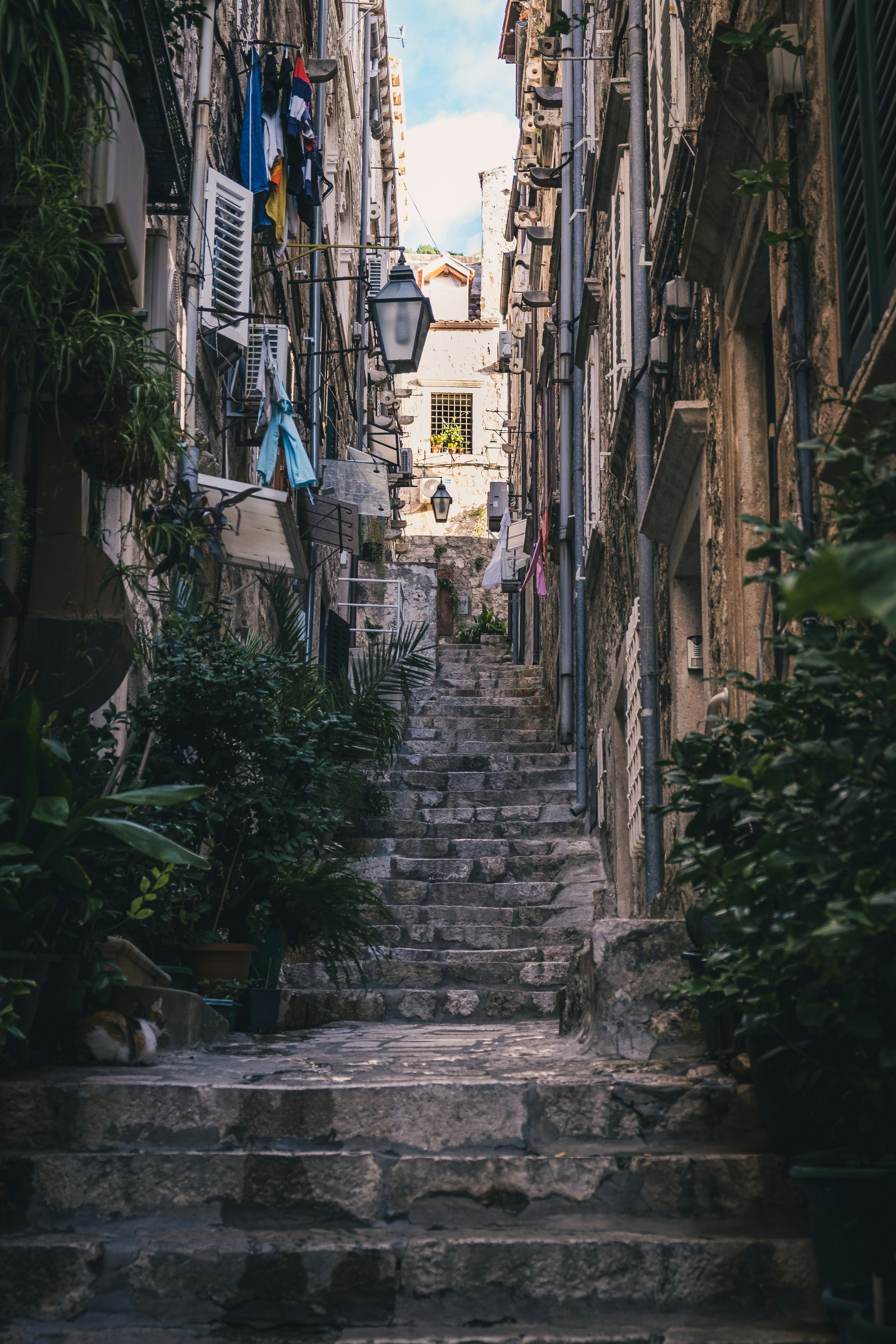 Narrow stone staircase in a quaint alley with laundry hanging