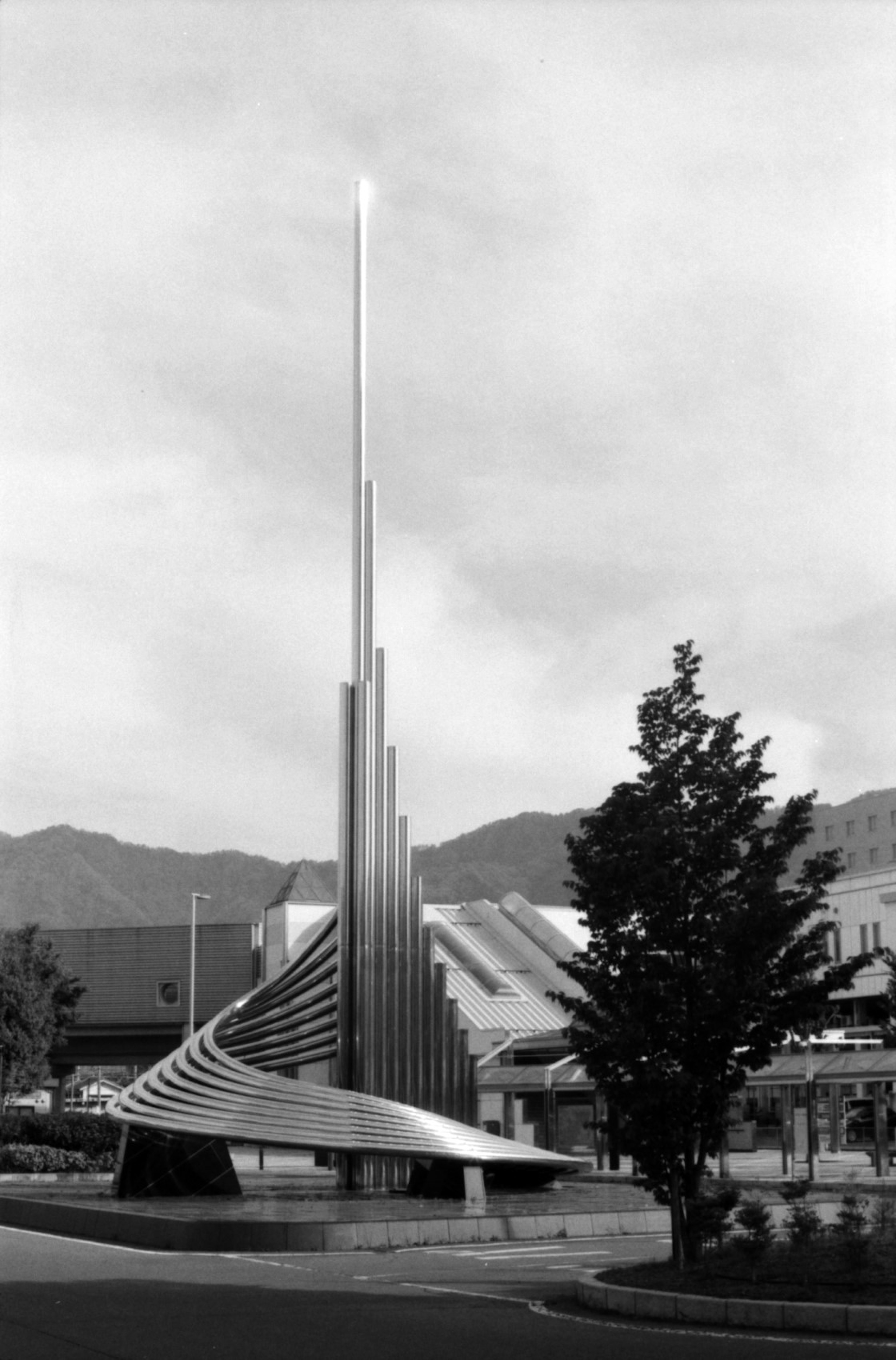 Modern sculpture with sleek lines surrounded by trees