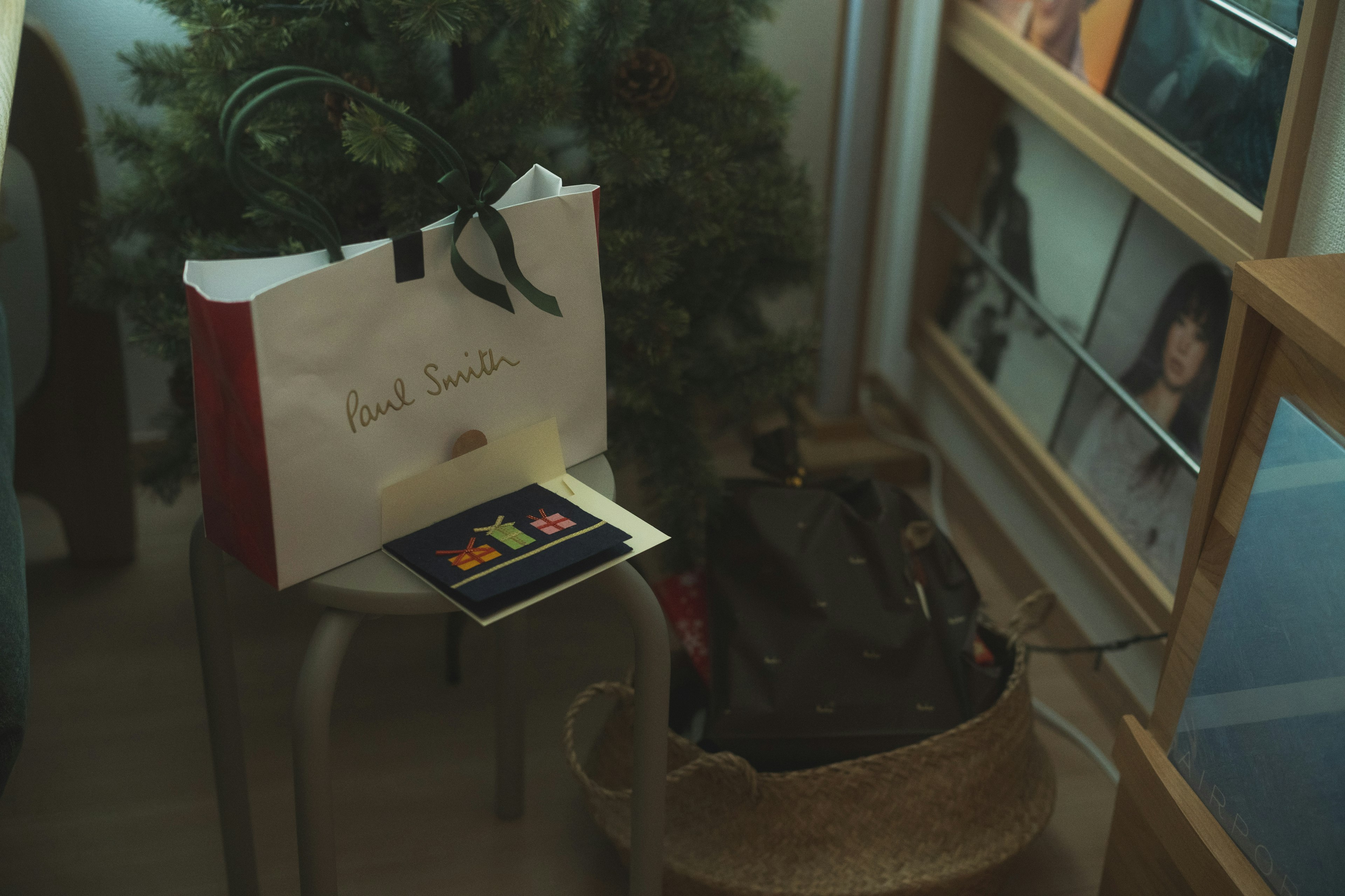 Interior scene with a gift bag and card near a Christmas tree