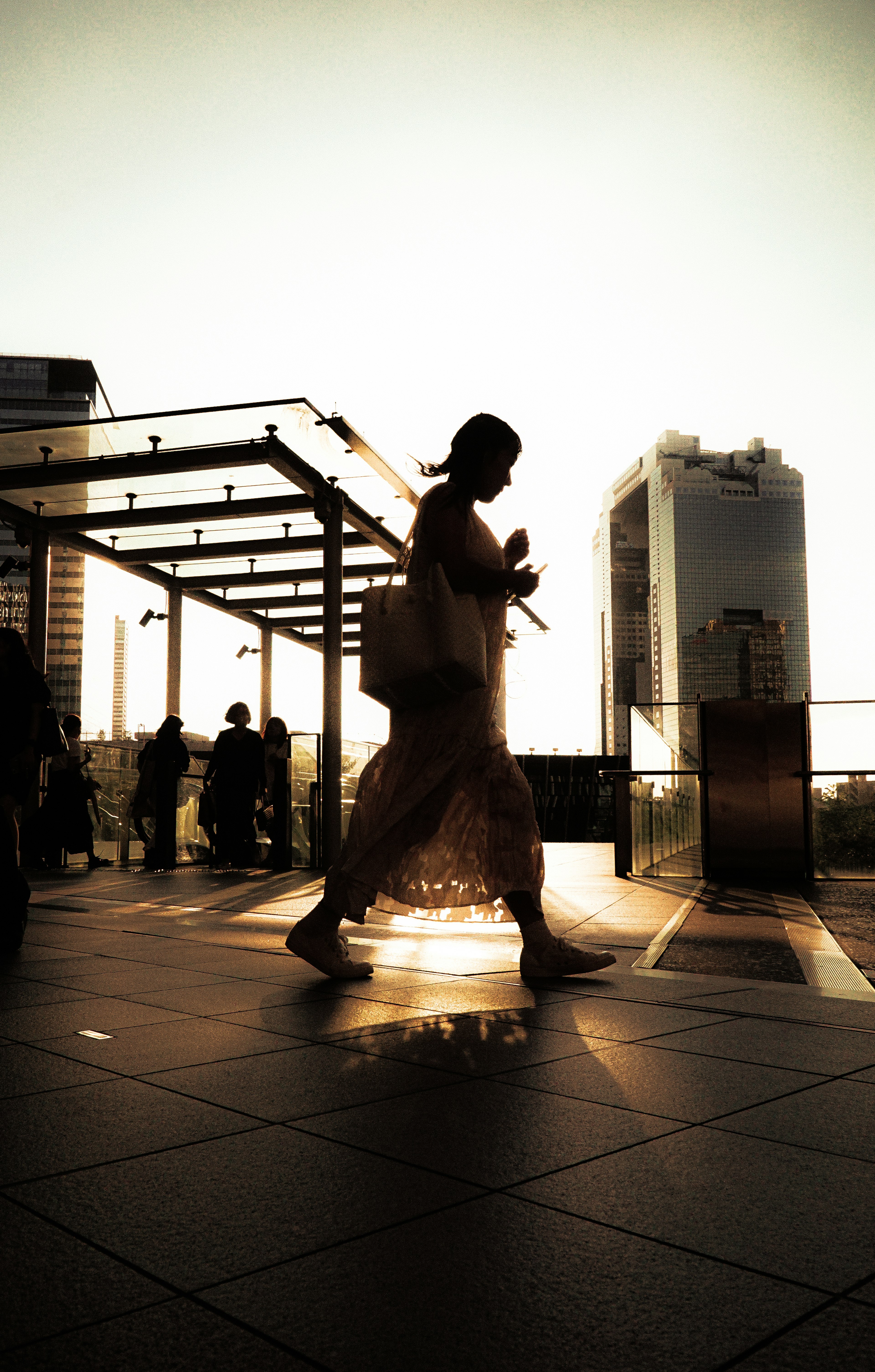 Silhouette di persone che camminano con sfondo di tramonto paesaggio urbano