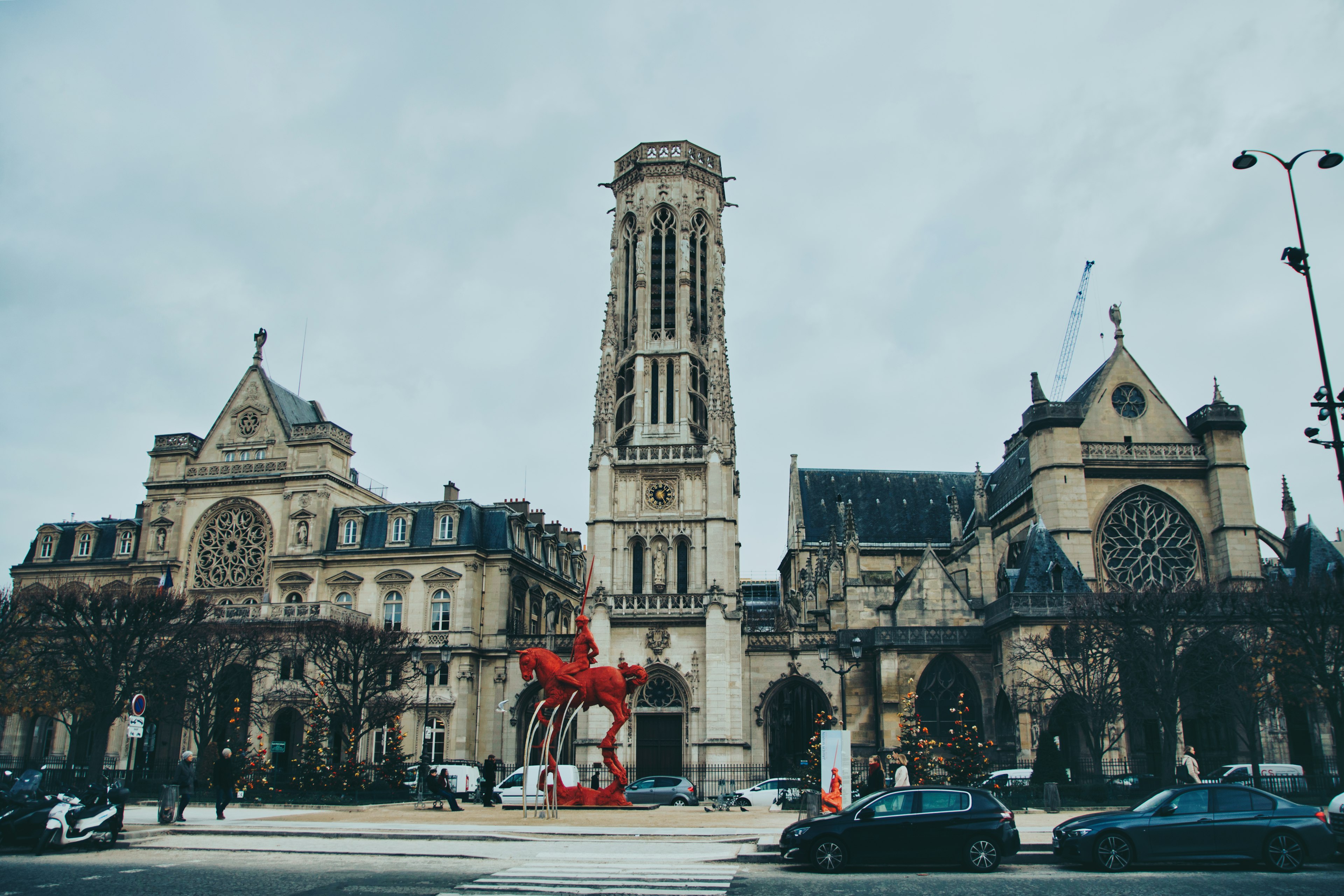 Pemandangan luar Menara Saint-Jacques dan gereja di Paris dengan patung merah di latar depan