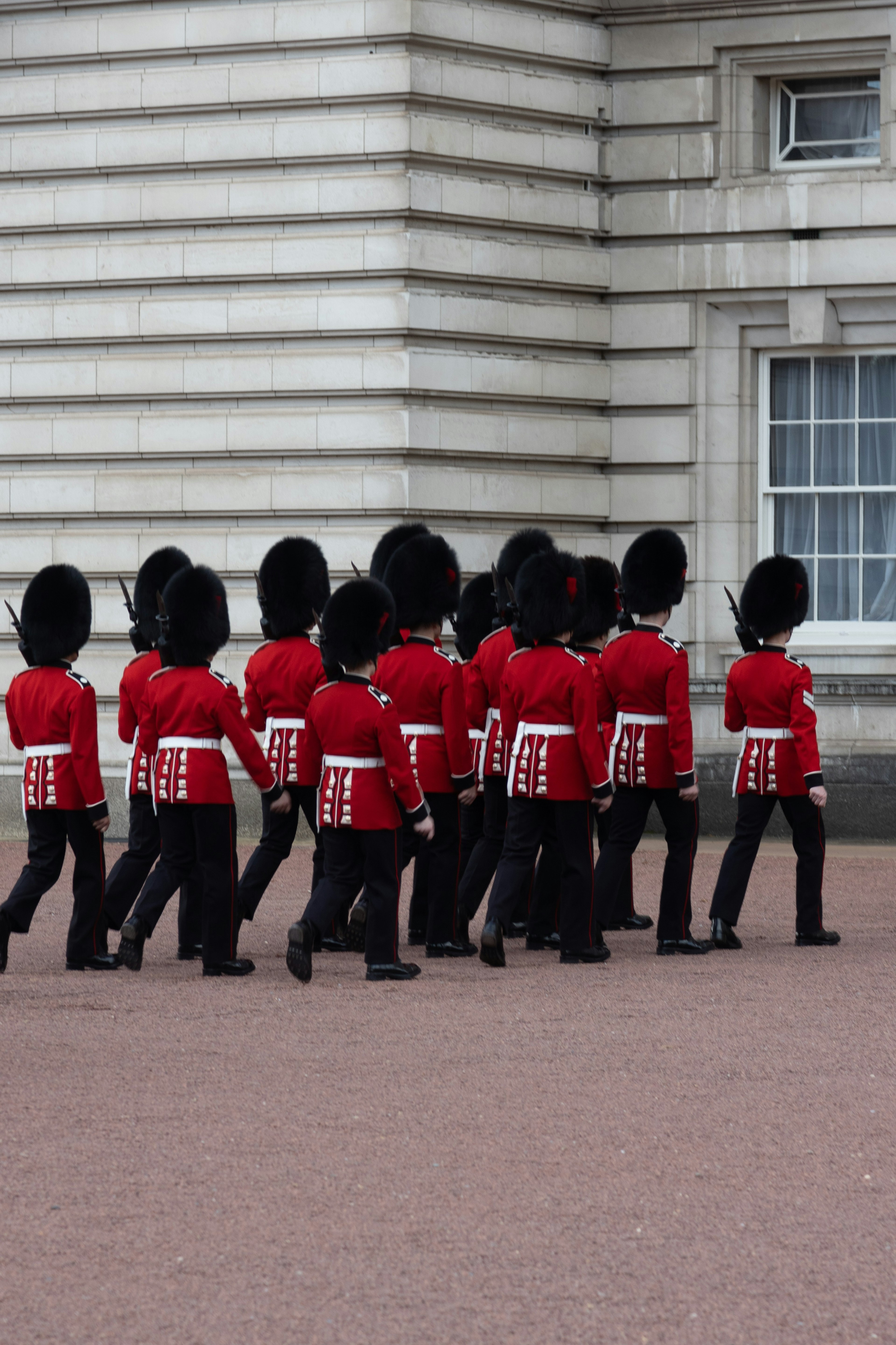 Foot guards in red uniforms marching at Buckingham Palace