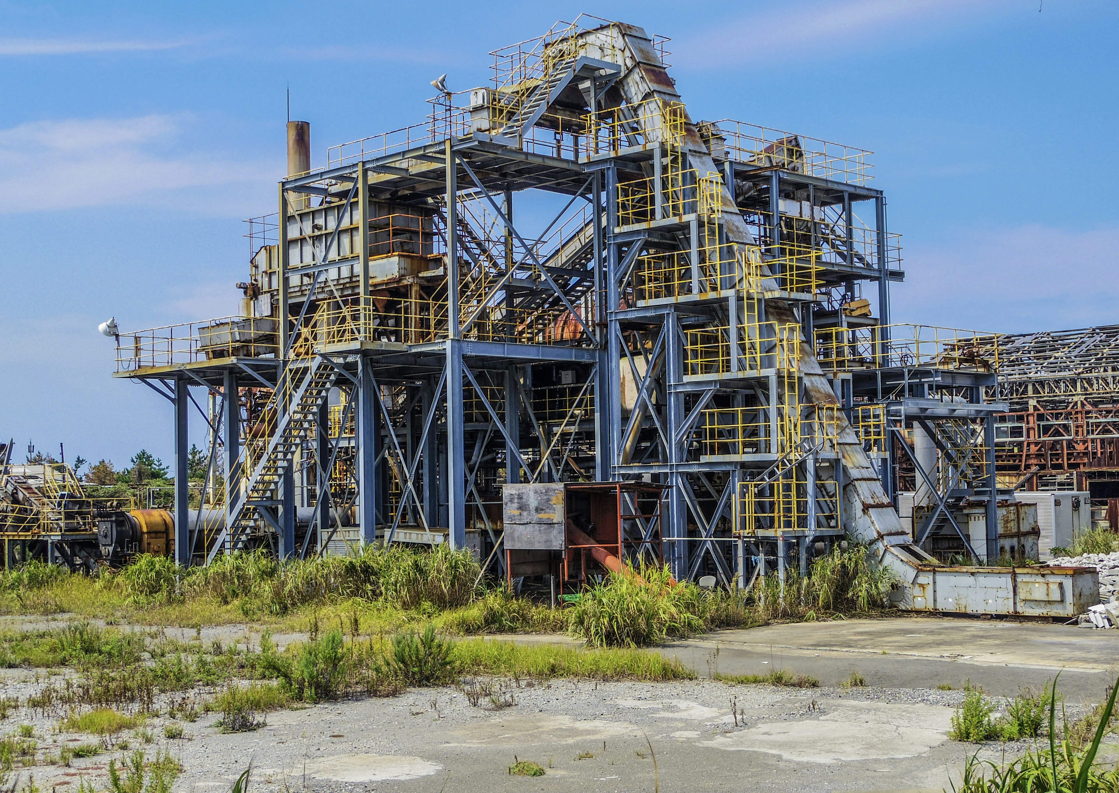 Structure industrielle abandonnée avec cadre métallique sous un ciel bleu