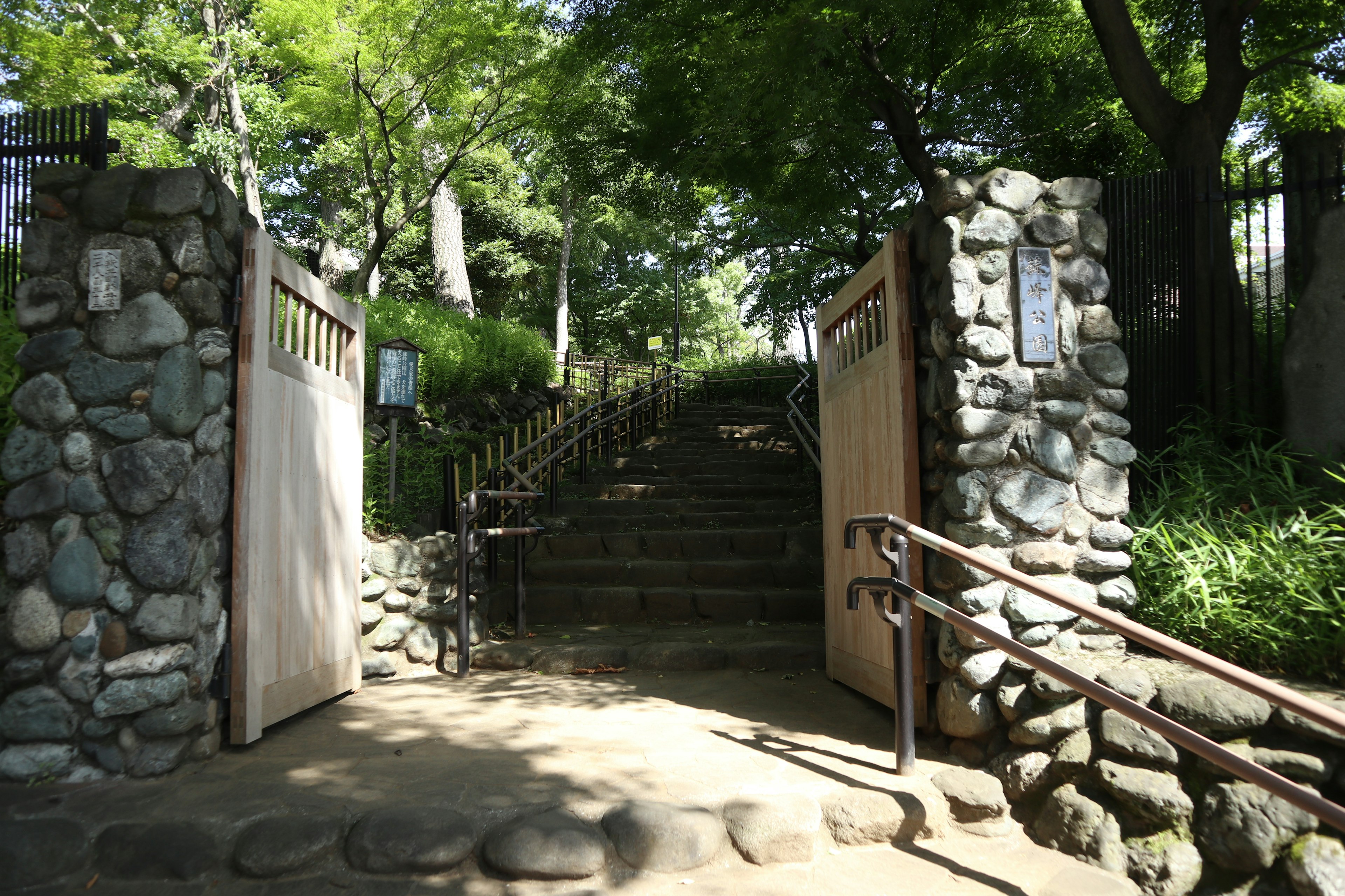 Puerta de piedra y escalera que conduce a un área verde