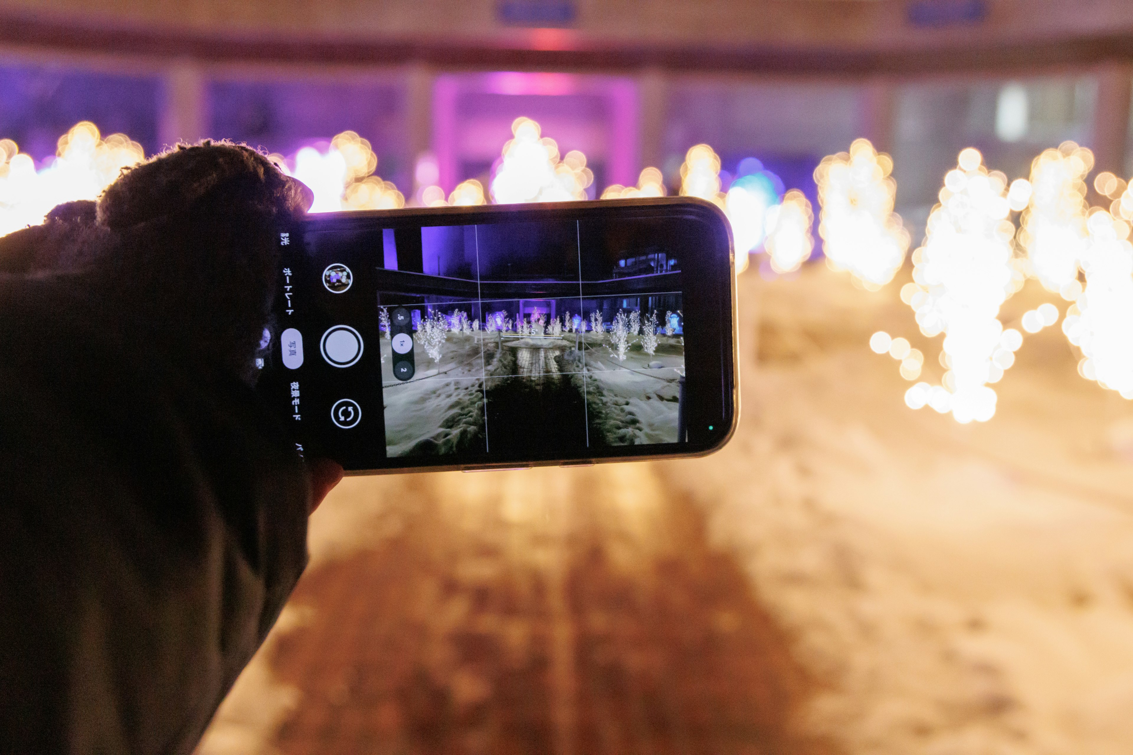 A smartphone capturing fire effects in a snowy environment