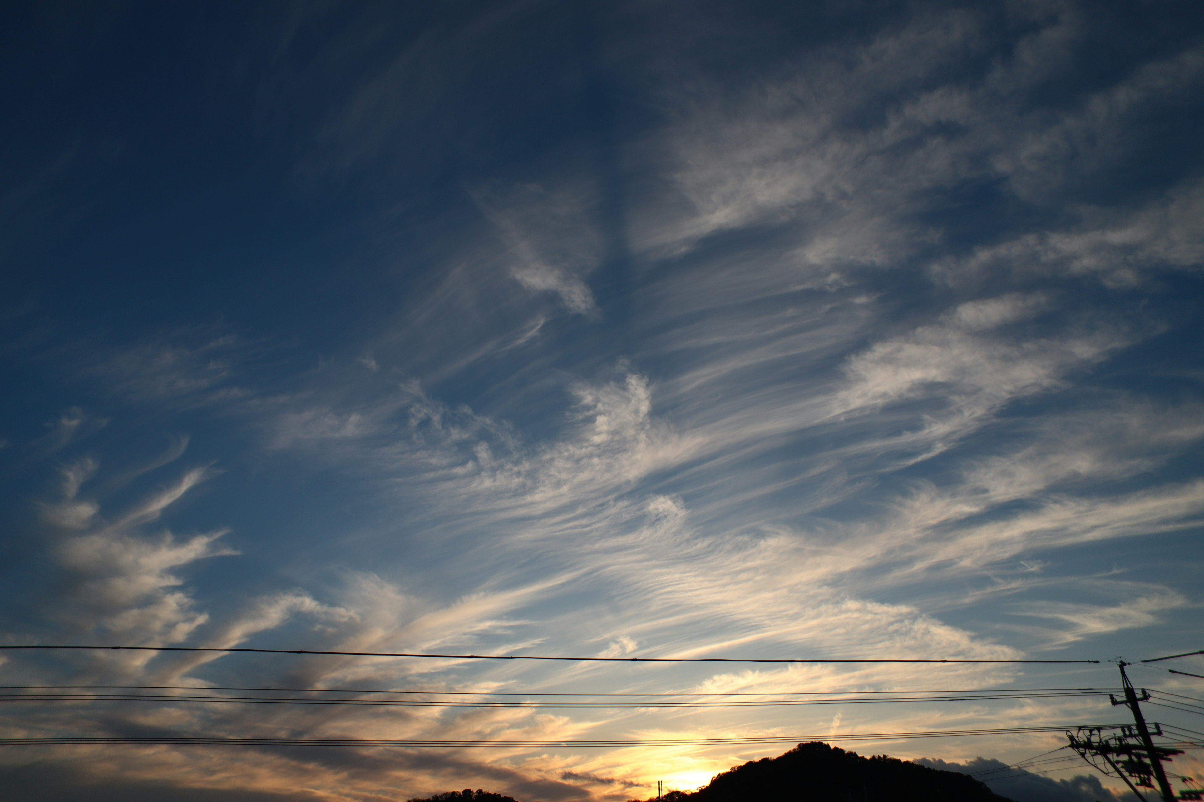 青空に広がる雲と夕日の美しい風景