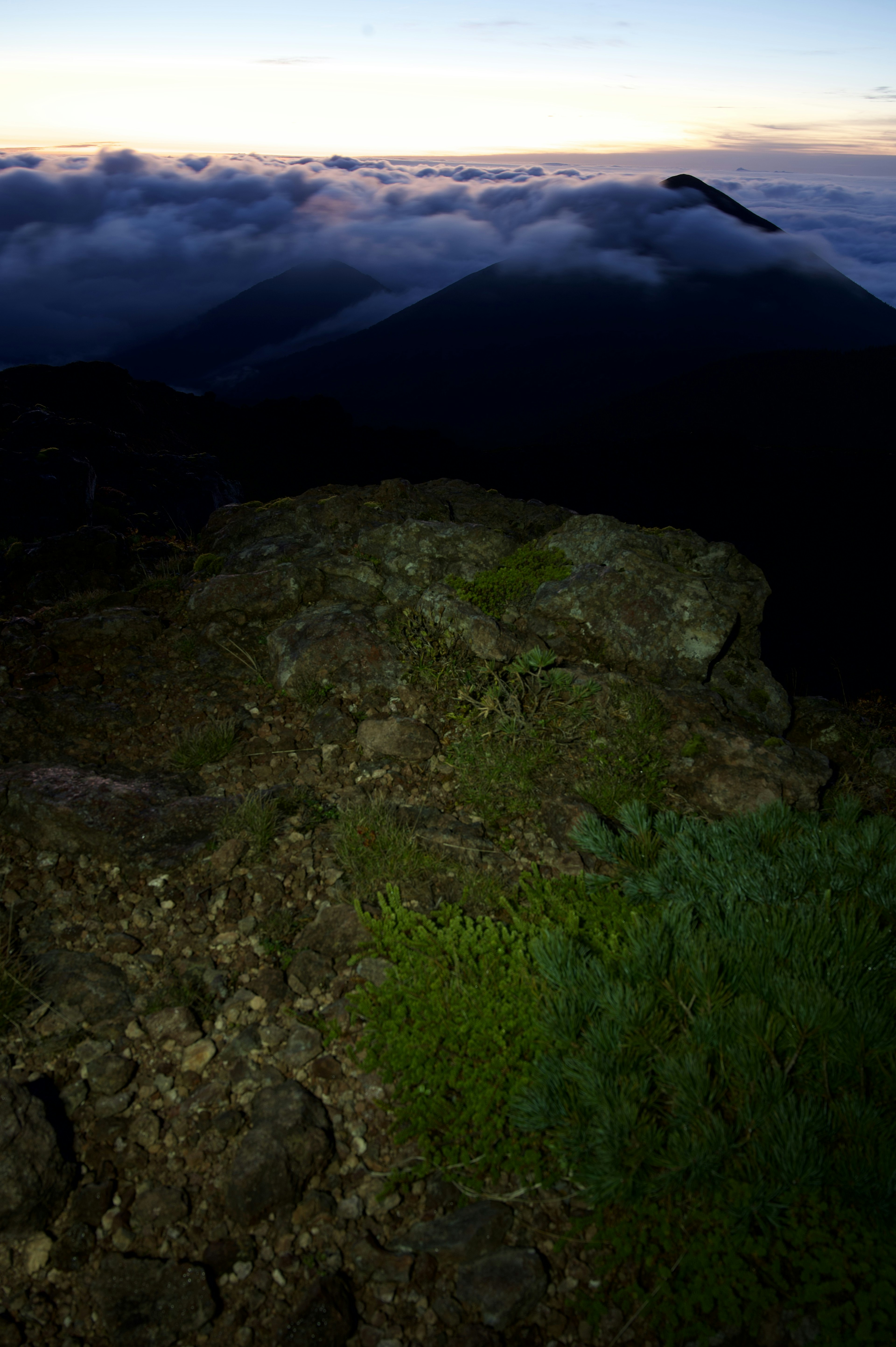 岩と草の景色の中に雲と山が広がる