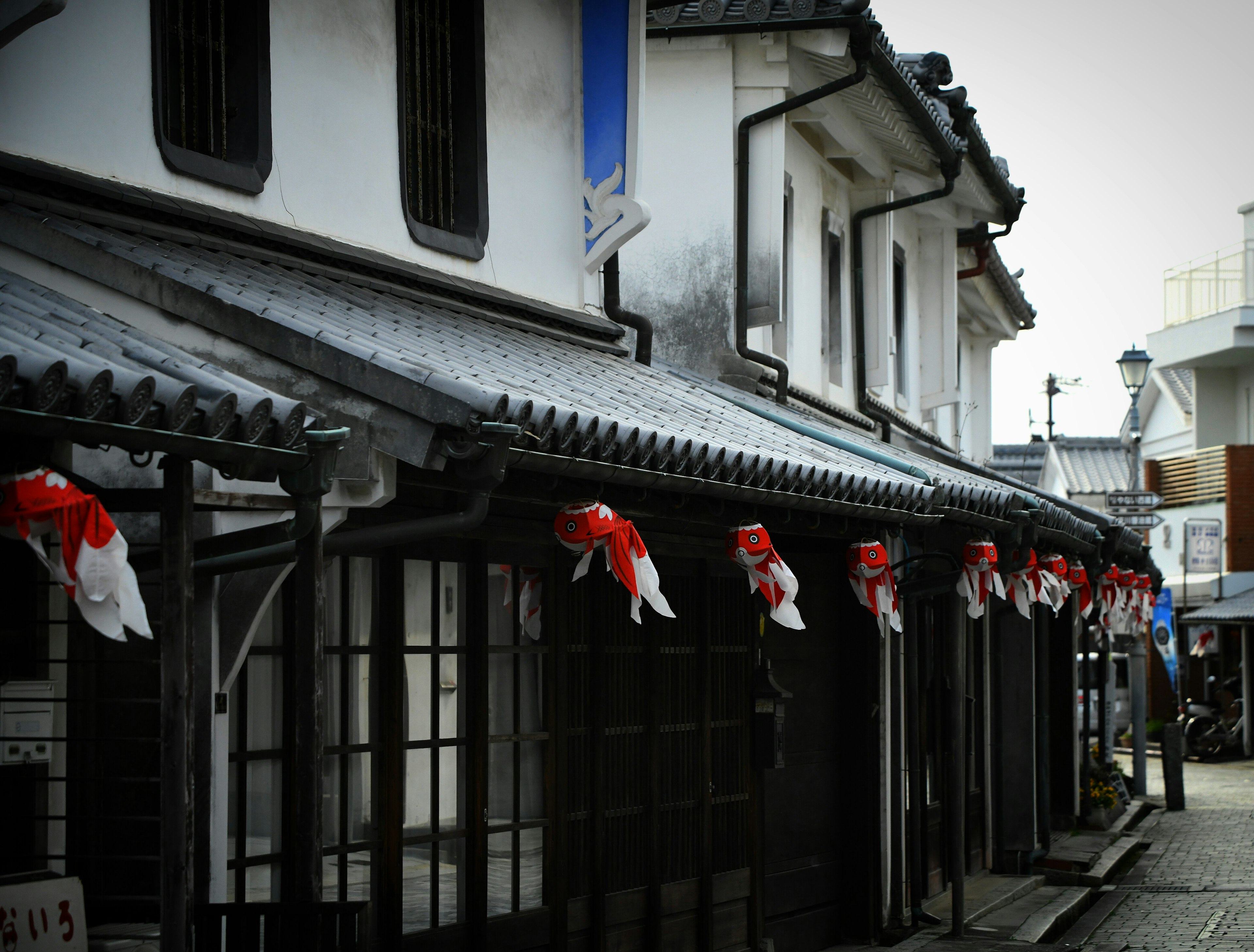 Traditional Japanese streetscape featuring buildings with red decorations on the roofs