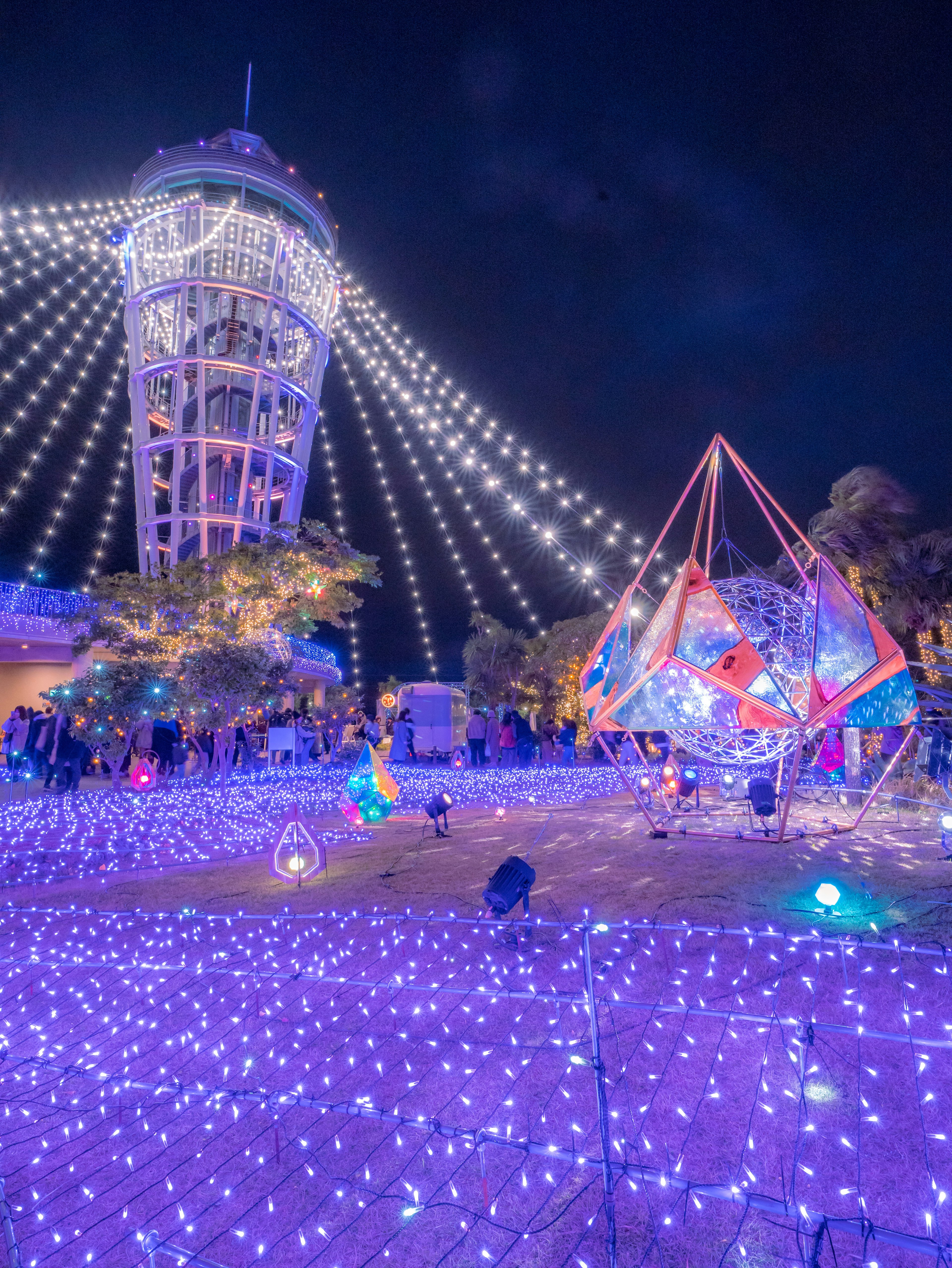 Escena nocturna con decoraciones iluminadas y una noria