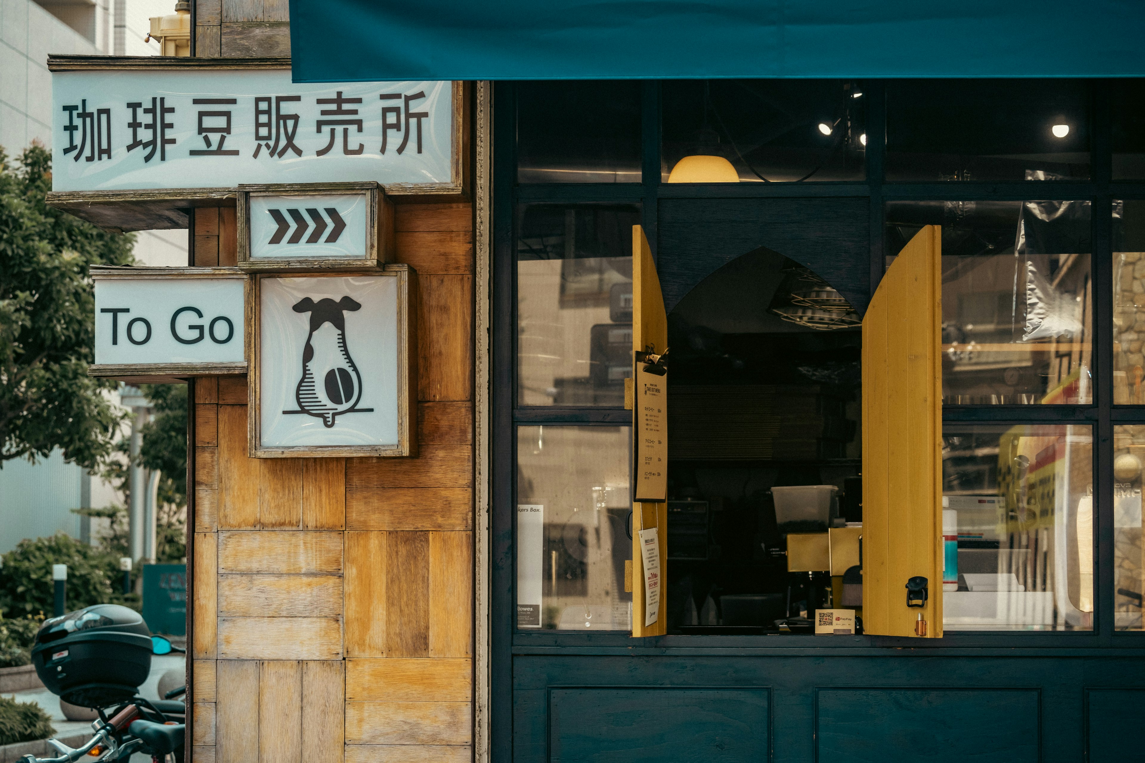 Café-Außenansicht mit gelben Fenstern, Hundeschild, To Go-Schild