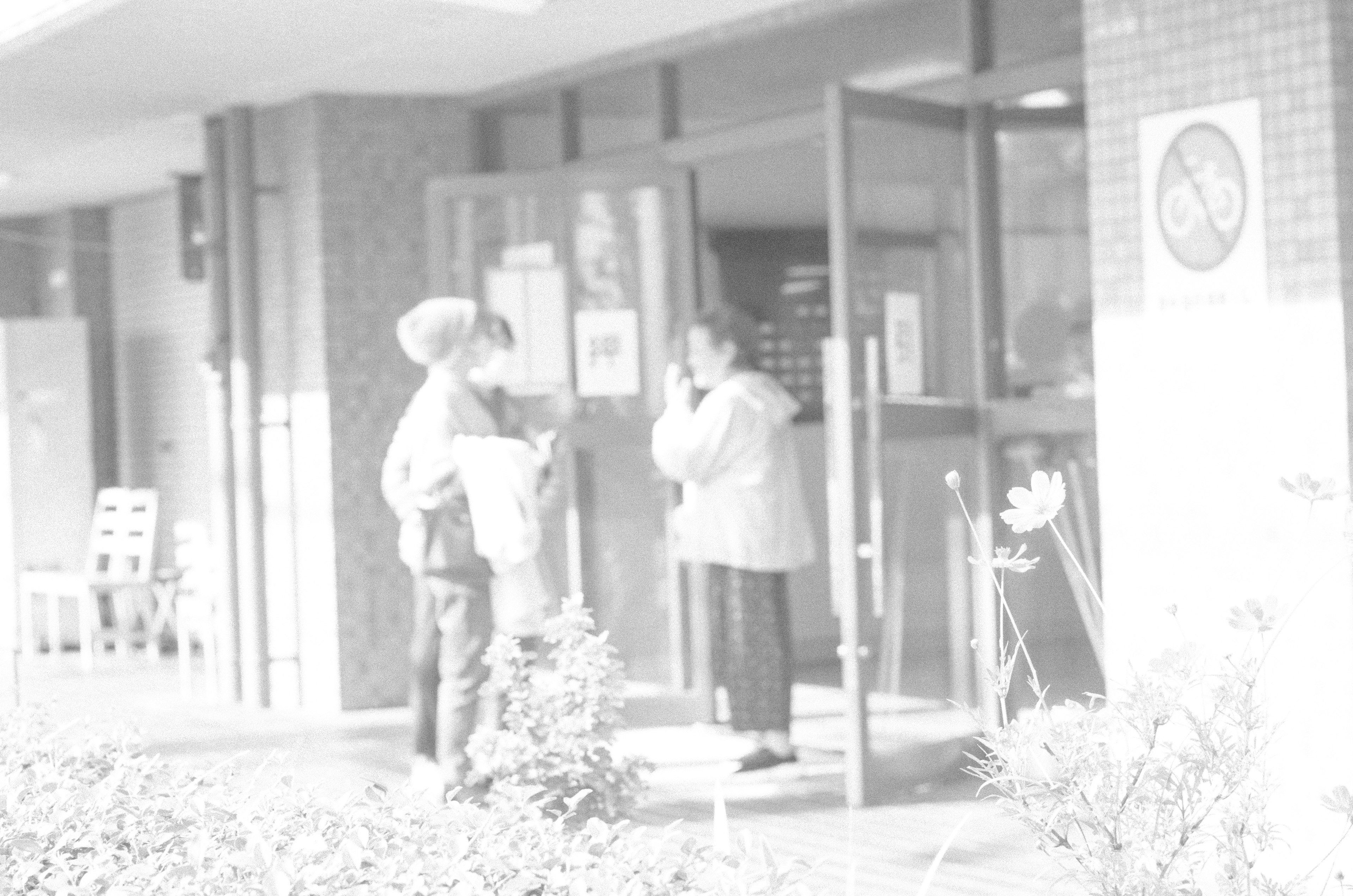 Two people conversing at the entrance of a building