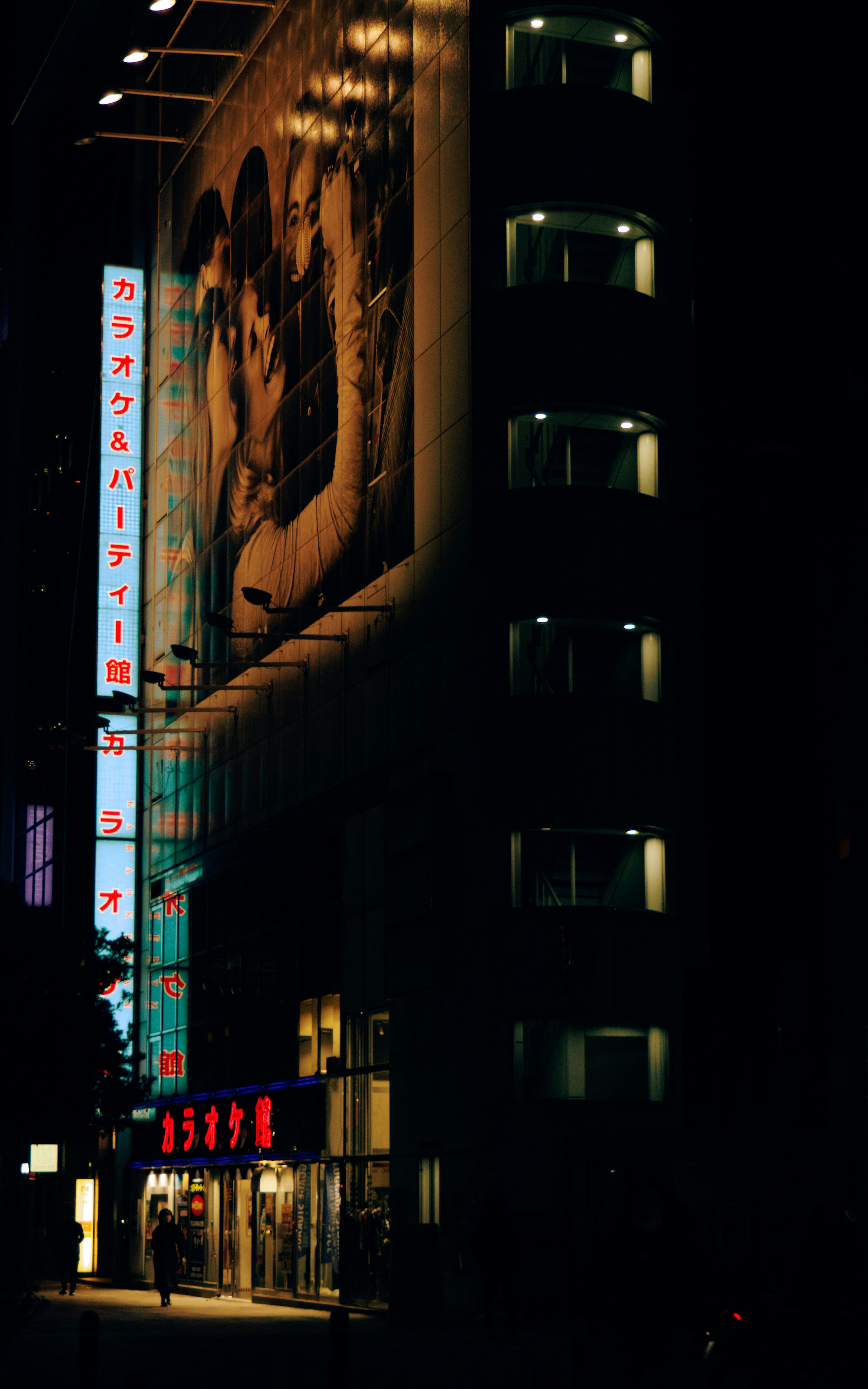 夜の街のビルに掲示された大きな広告と明るいネオン