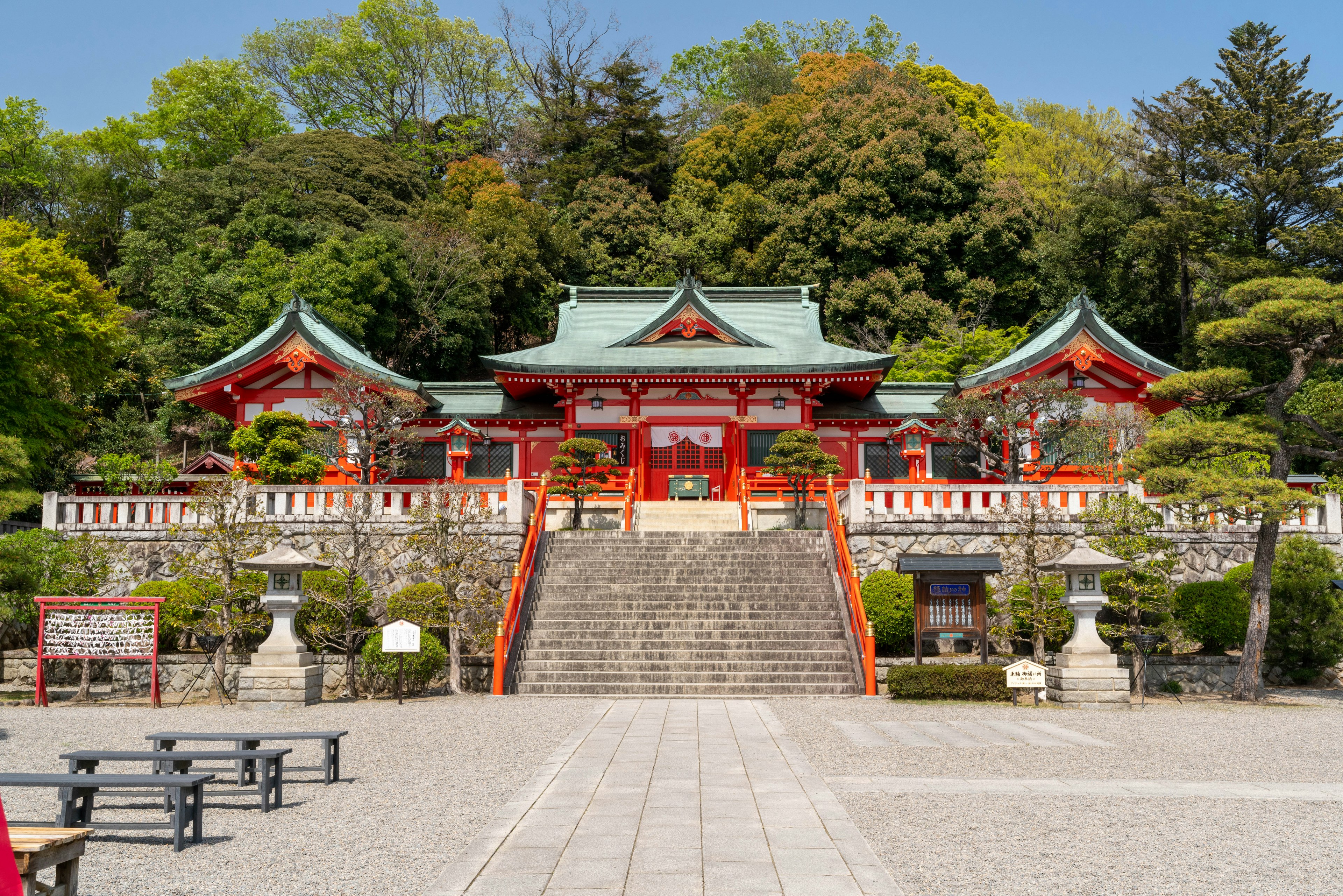 Shinto shrine with a red roof surrounded by greenery