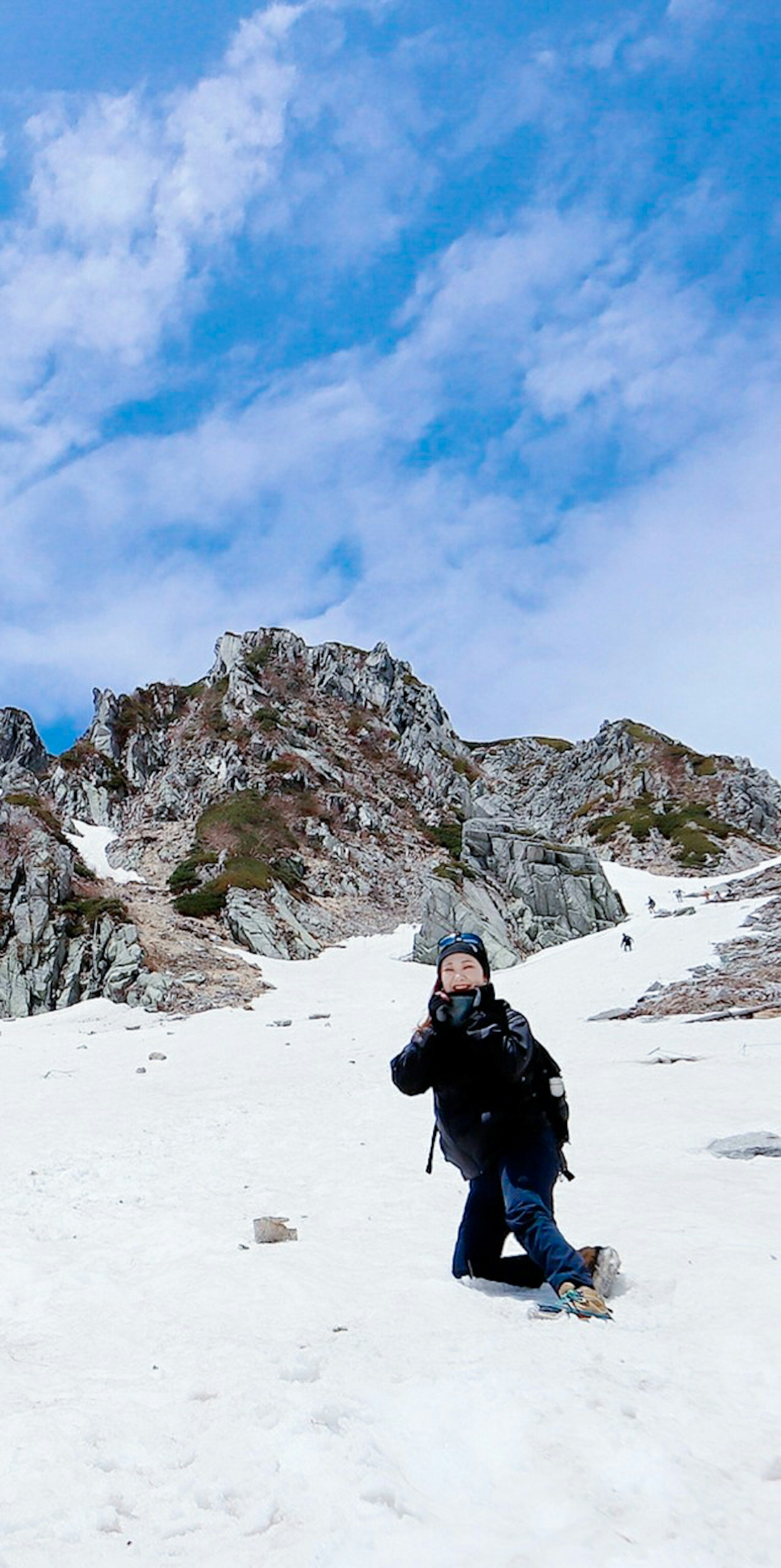 Randonneur posant dans la neige avec un paysage de montagne accidentée