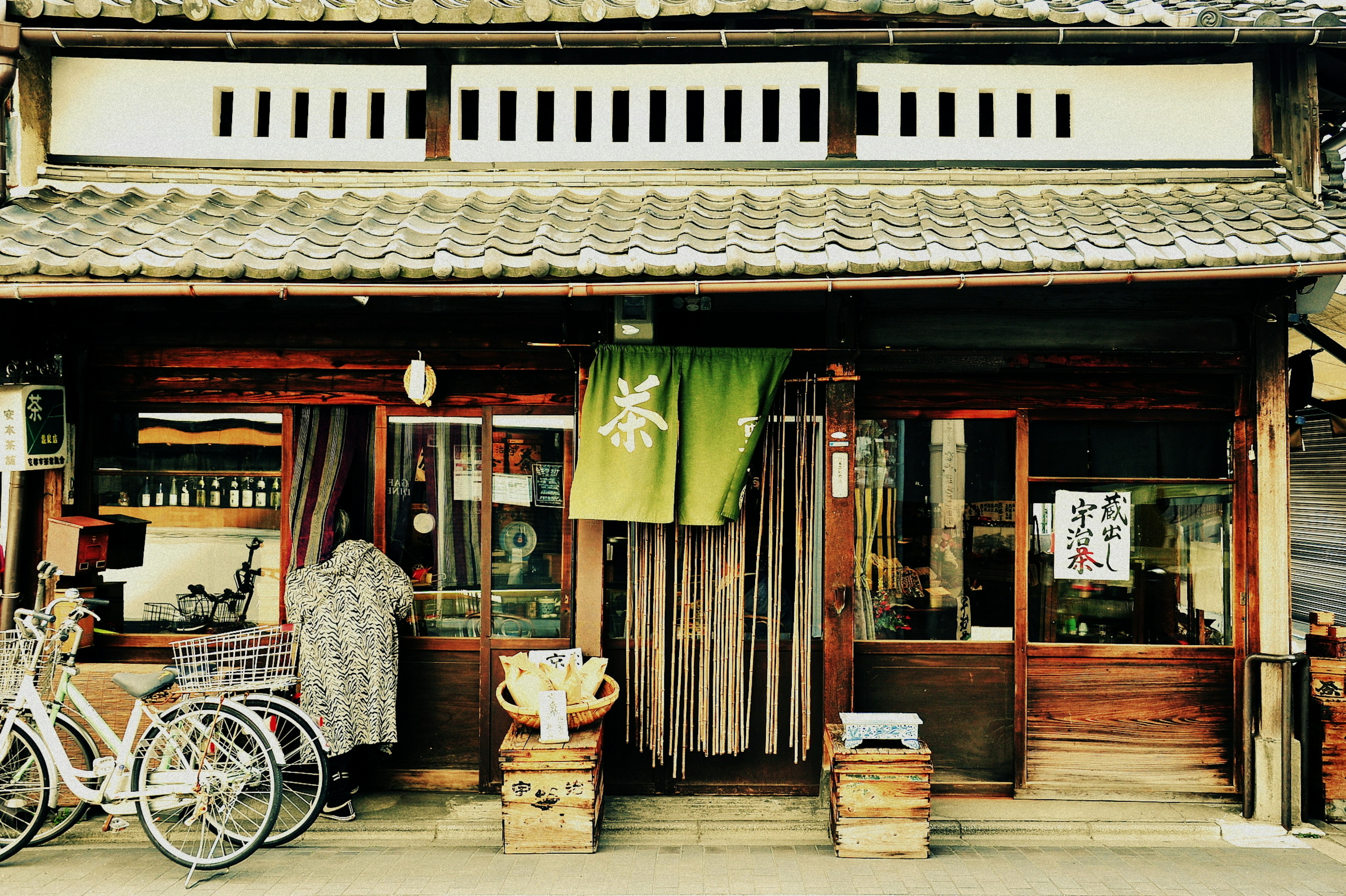 Fachada de una tienda japonesa tradicional con una bicicleta y cajas de madera