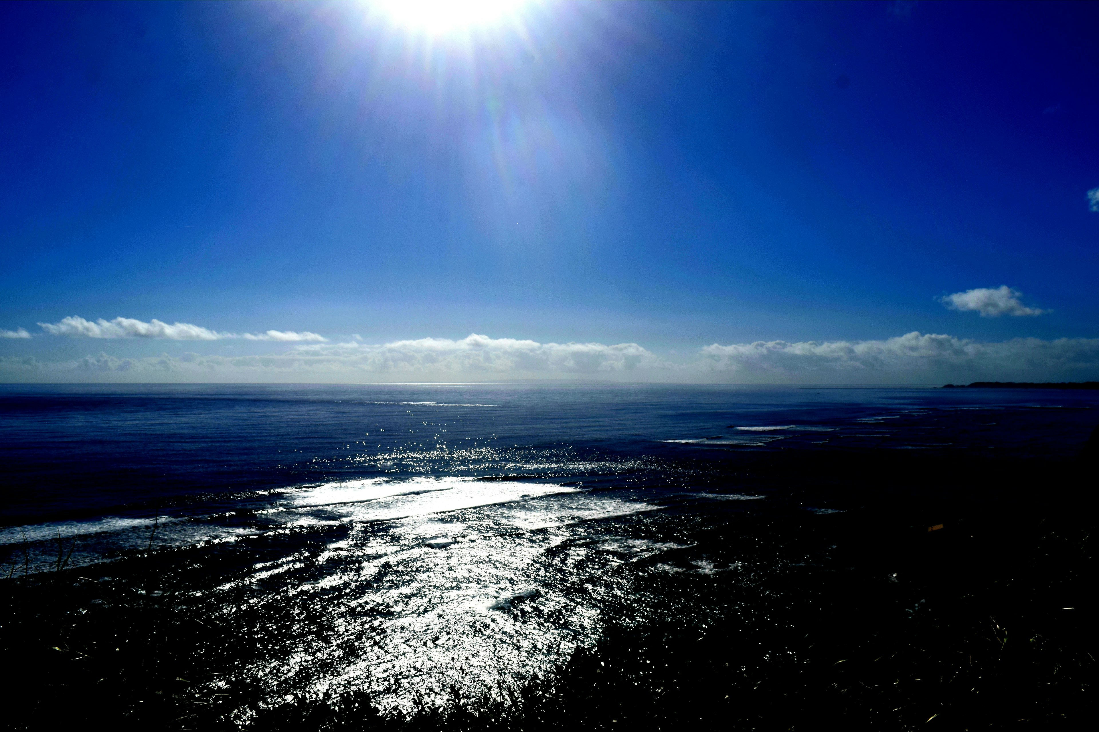 青い空と太陽が輝く海の風景 反射する水面が美しい