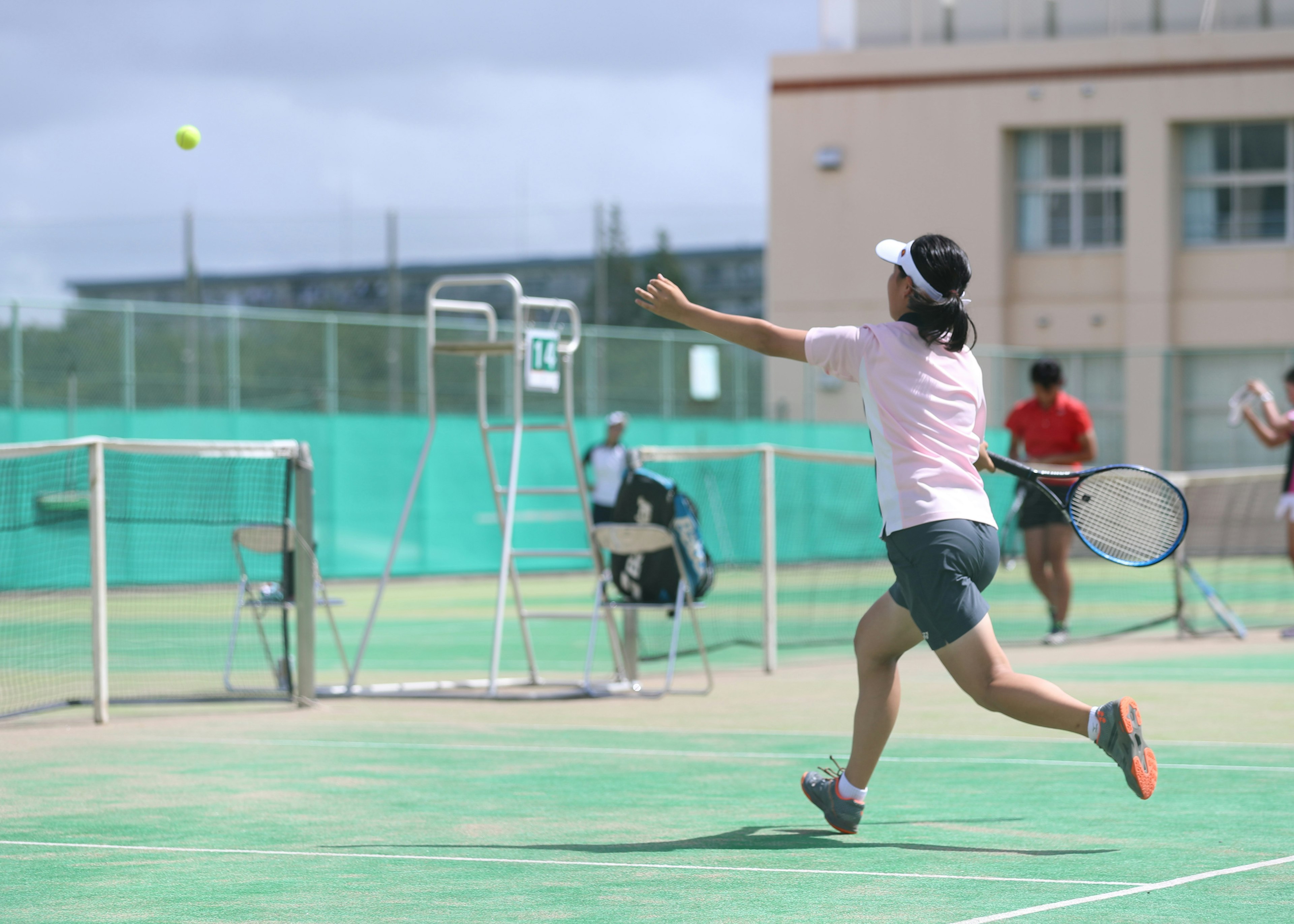 Jugadora de tenis golpeando una pelota en la cancha