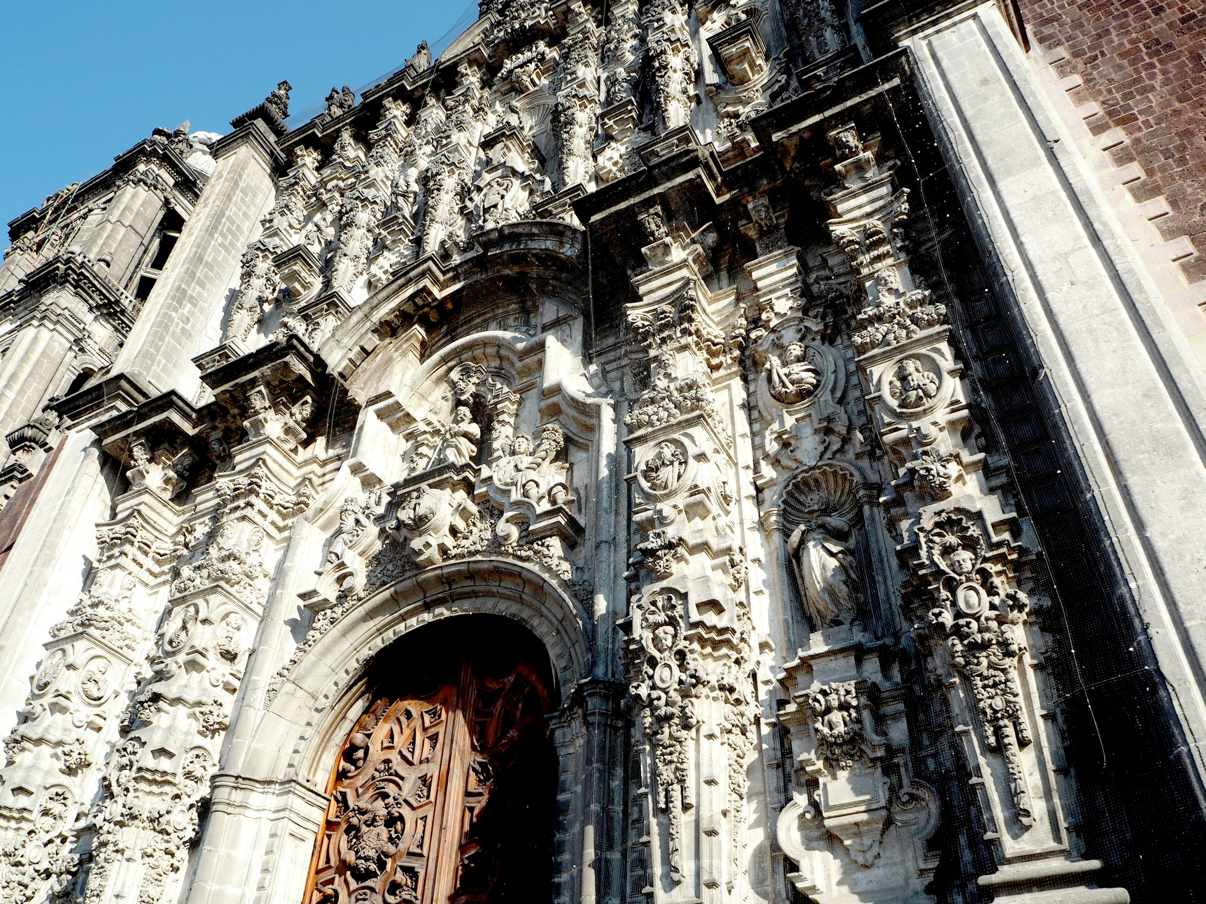 Façade baroque élaborée avec sculptures détaillées et porte en bois