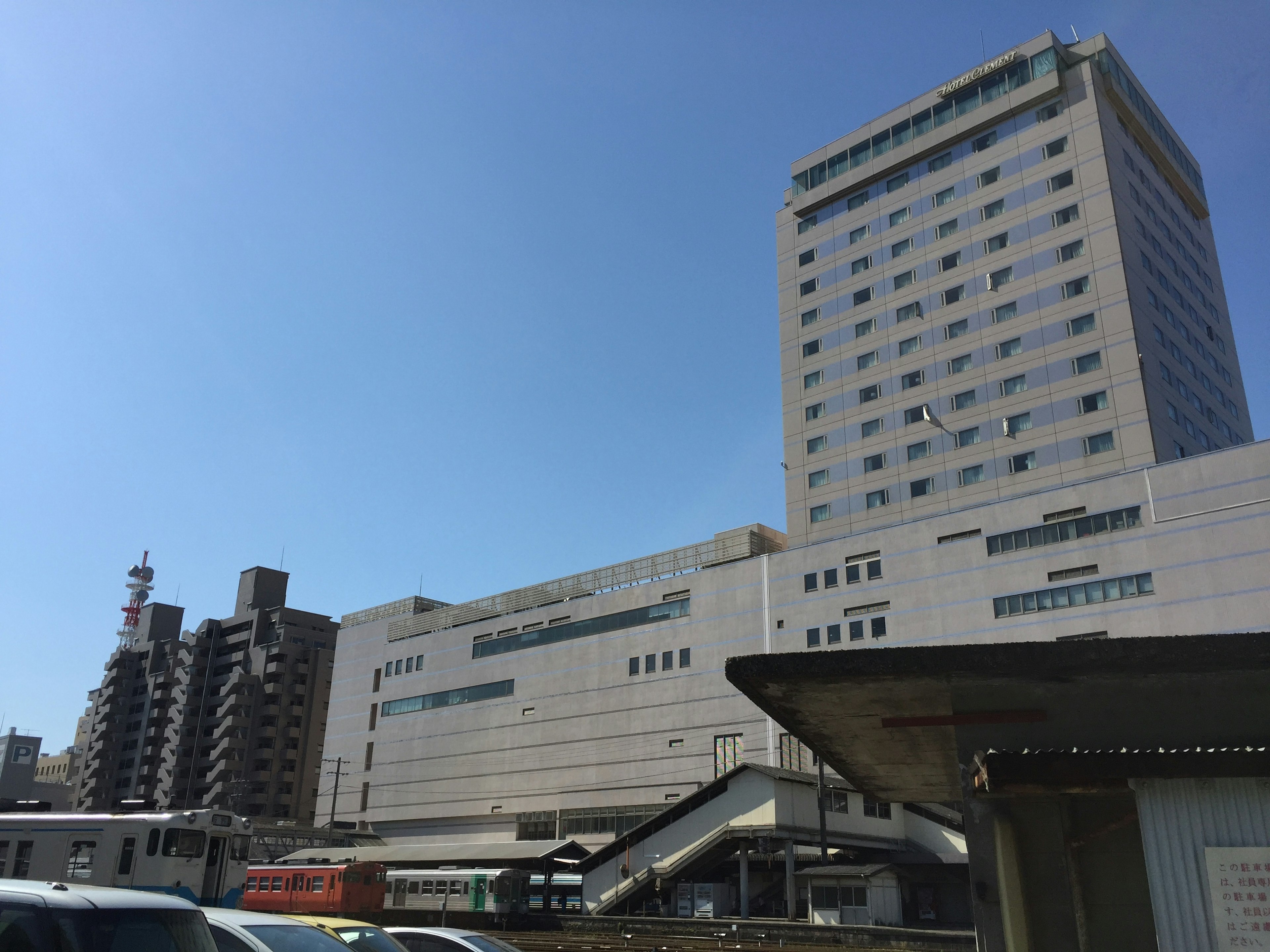 Paisaje urbano con un edificio alto bajo un cielo azul claro