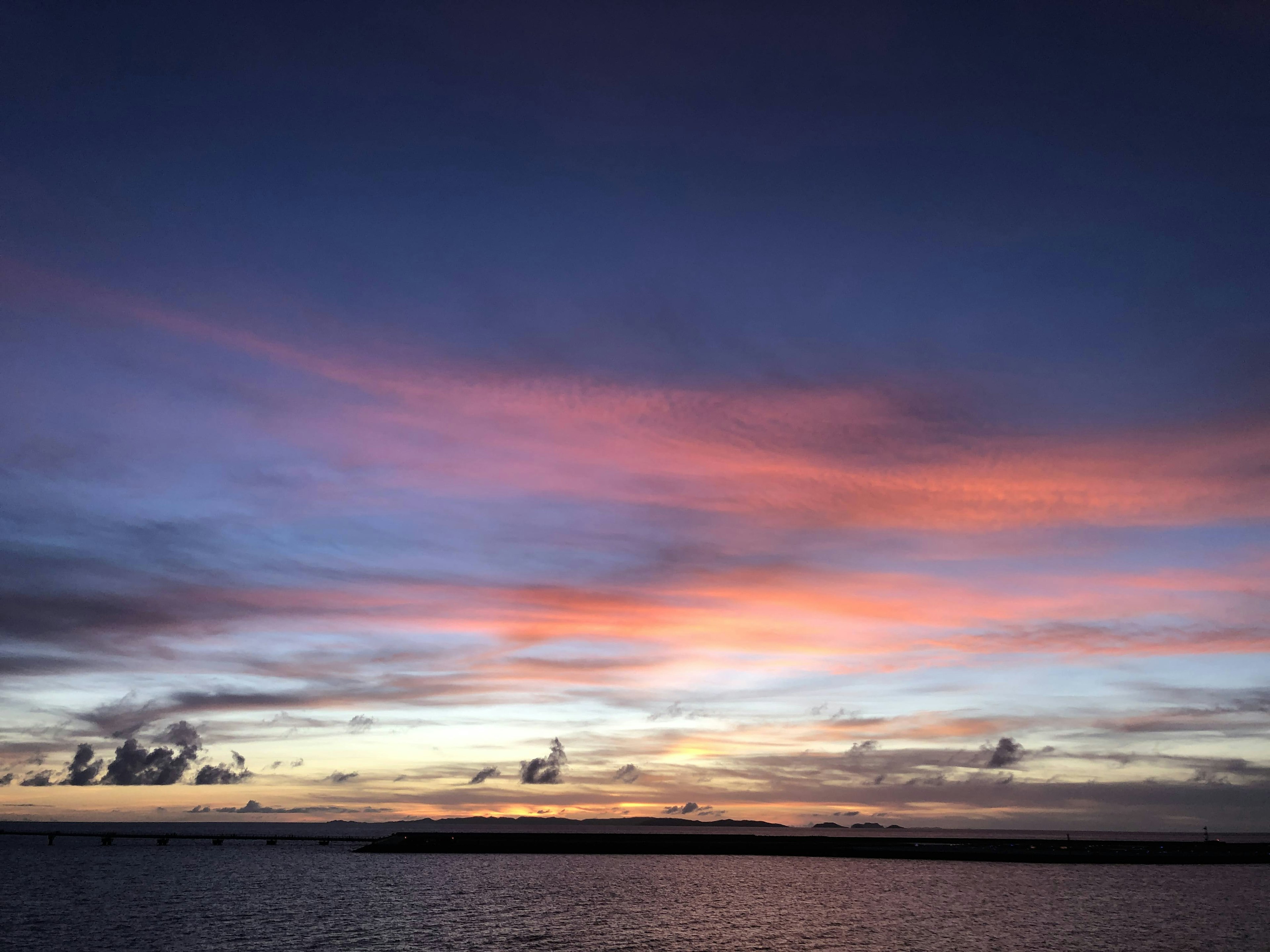 Coucher de soleil sur la mer avec des nuages colorés et des eaux calmes