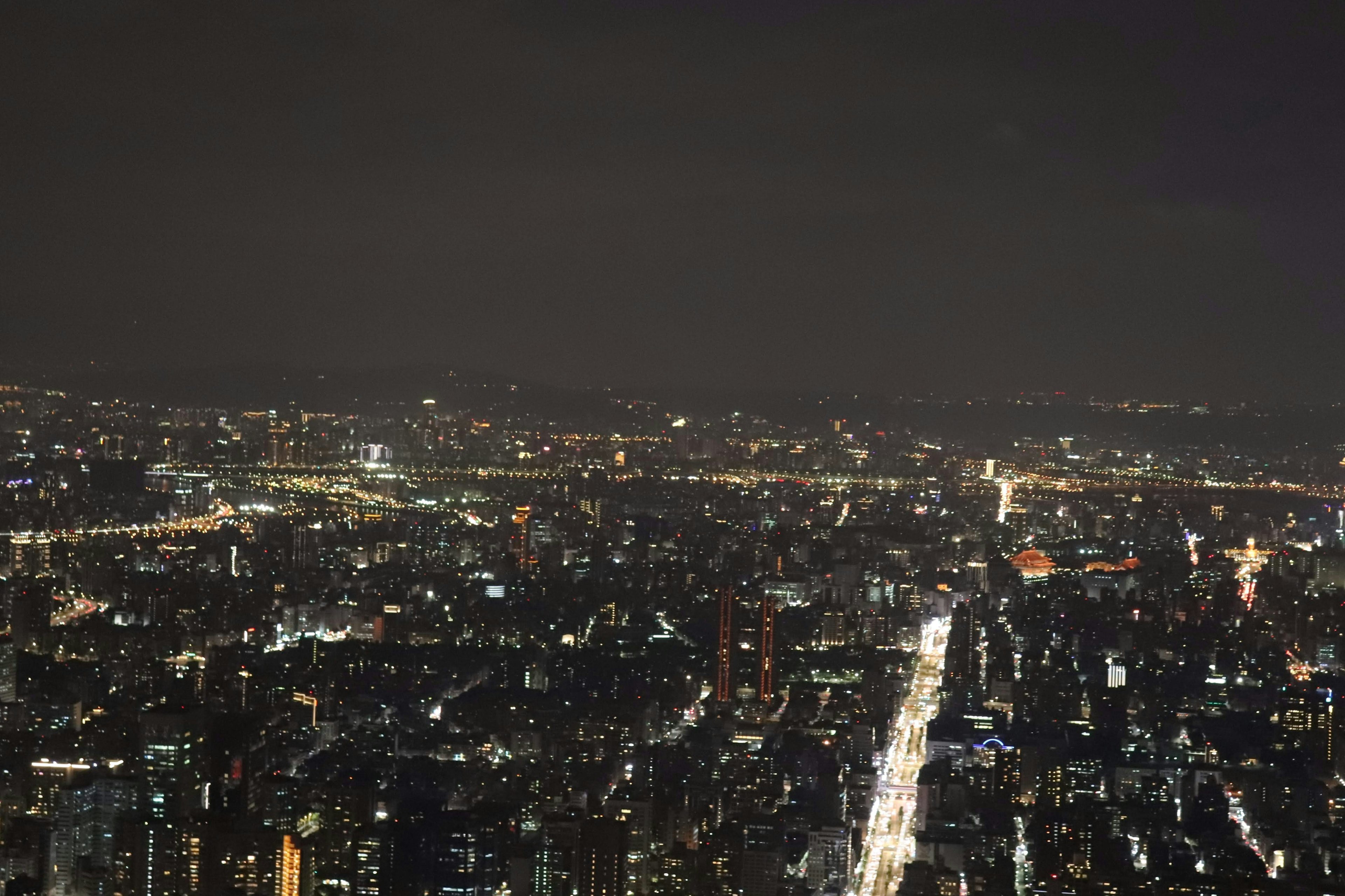 Panorama de la ville la nuit avec des lumières vives dans le ciel