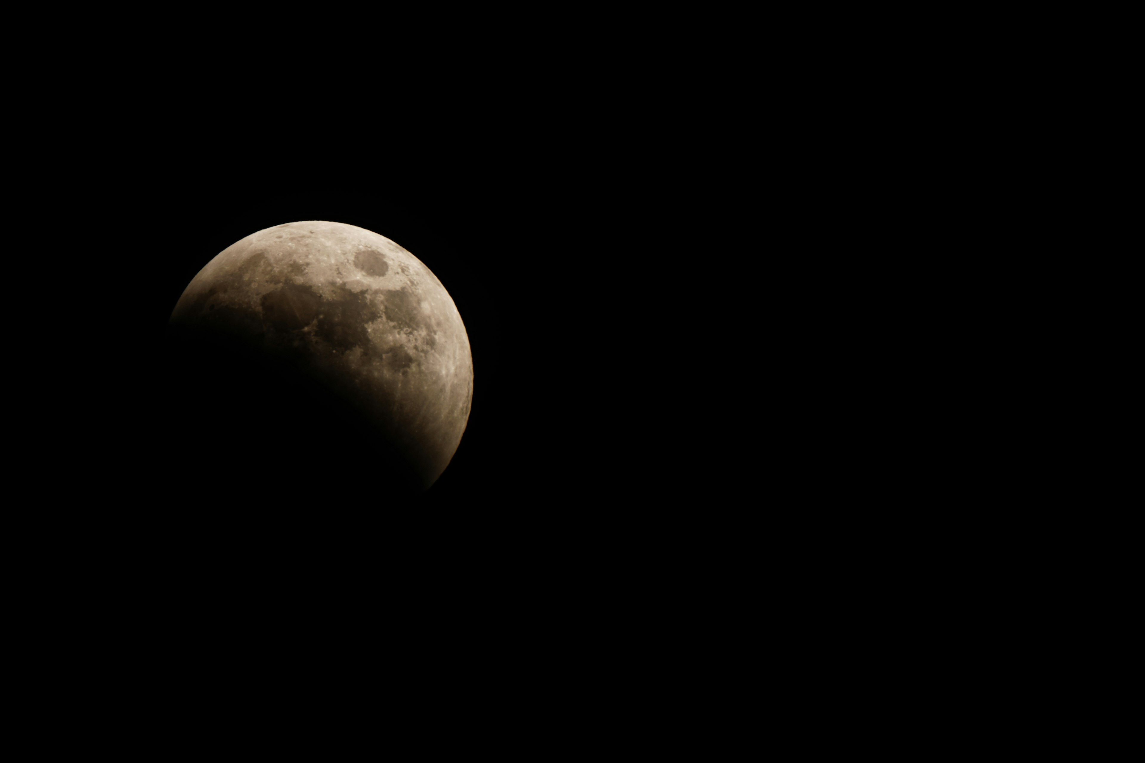 Gambar langit malam yang indah dengan bulan sebagian dalam bayangan