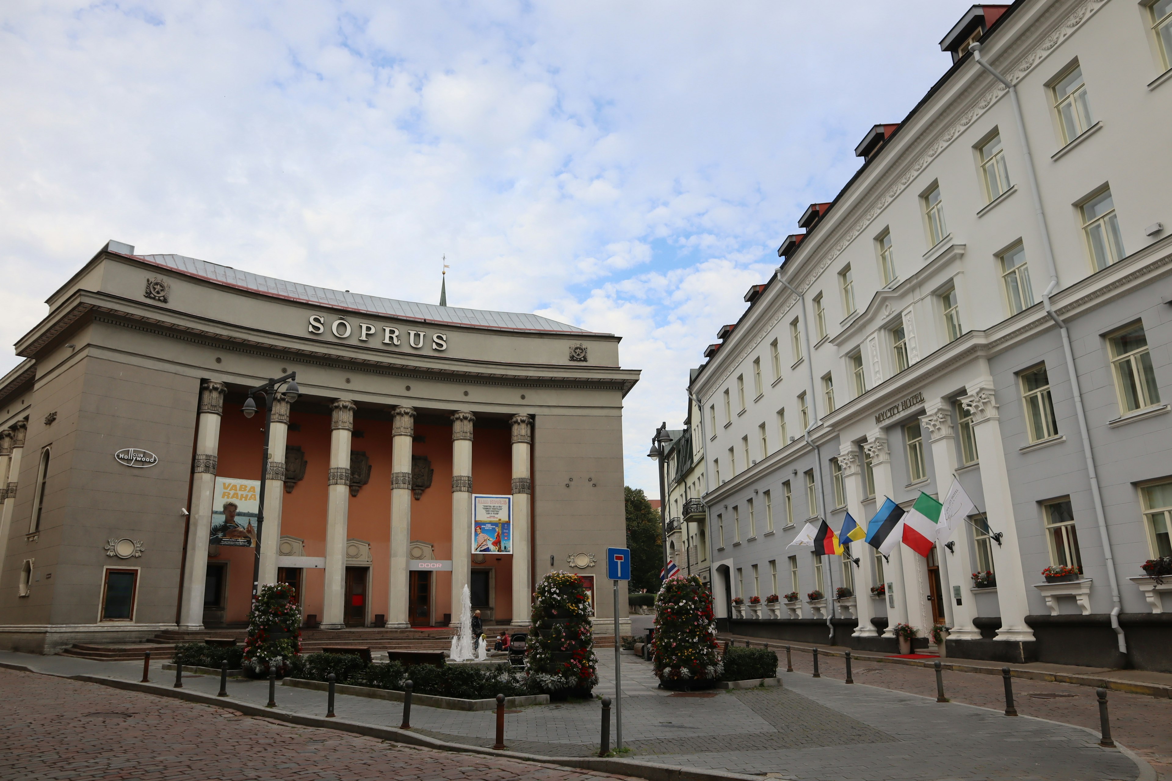 Vista de una plaza con edificios y banderas de diferentes países