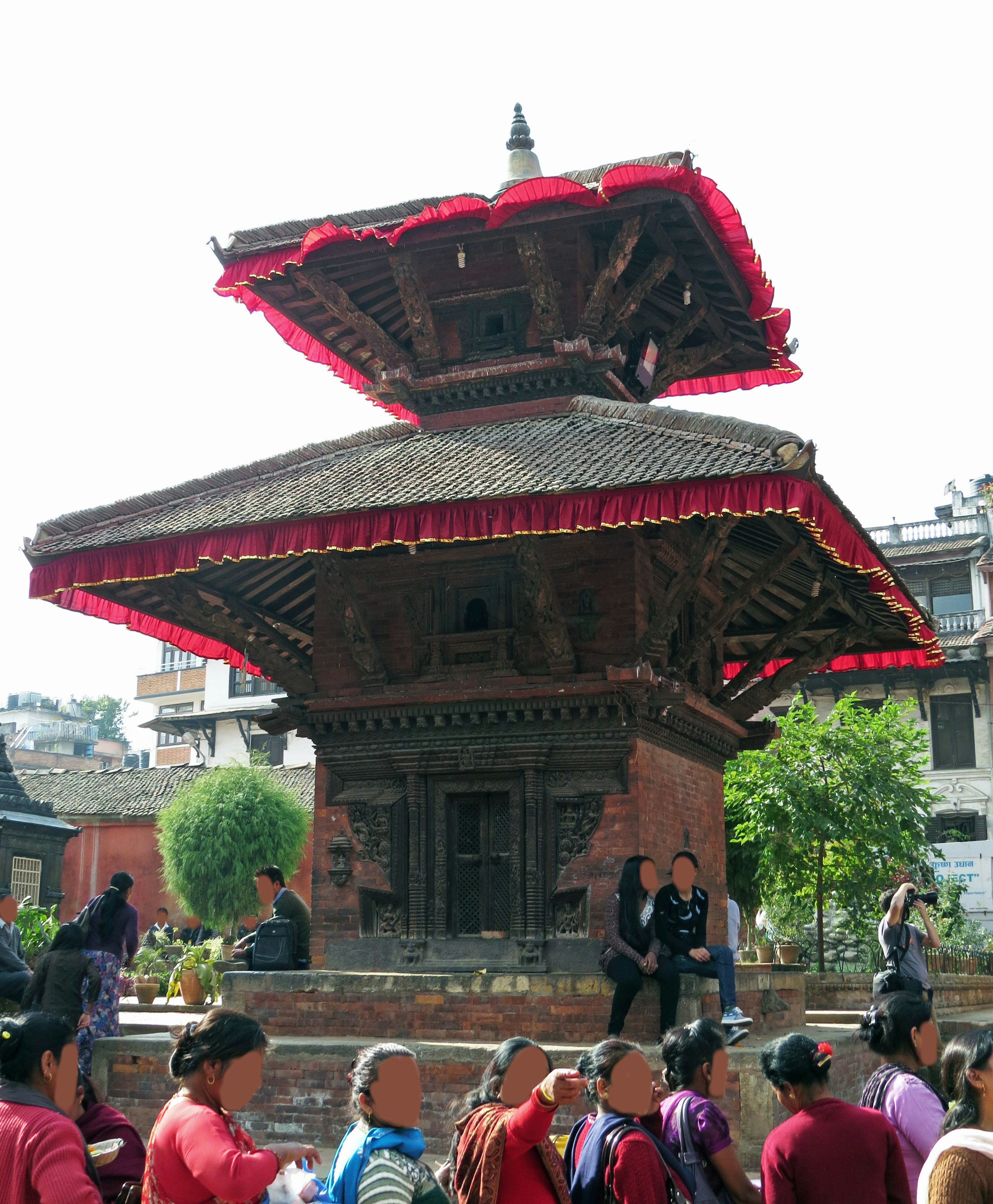 Kuil tradisional Nepal dengan atap merah dikelilingi orang-orang