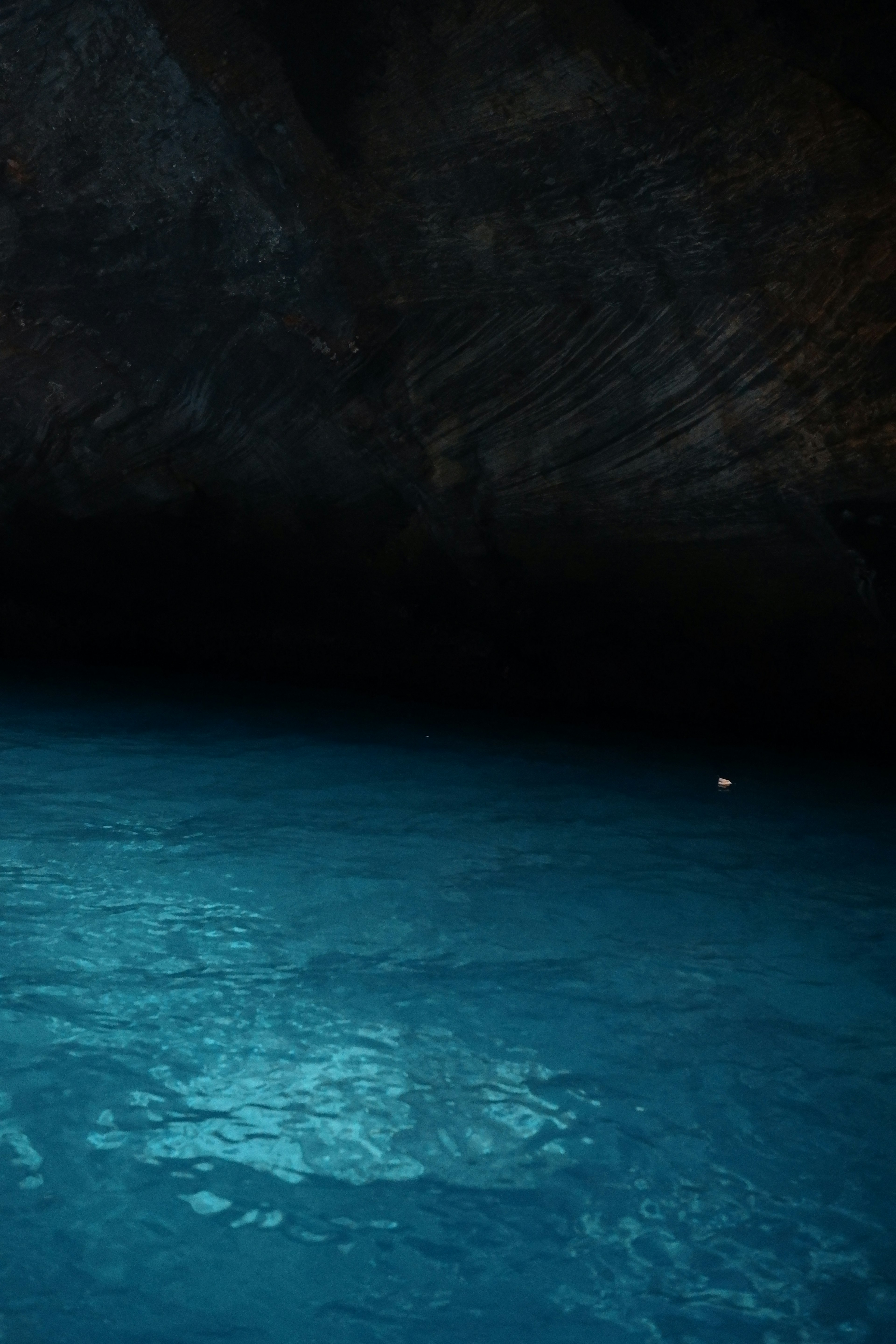 Grotte sombre avec surface d'eau bleue scintillante