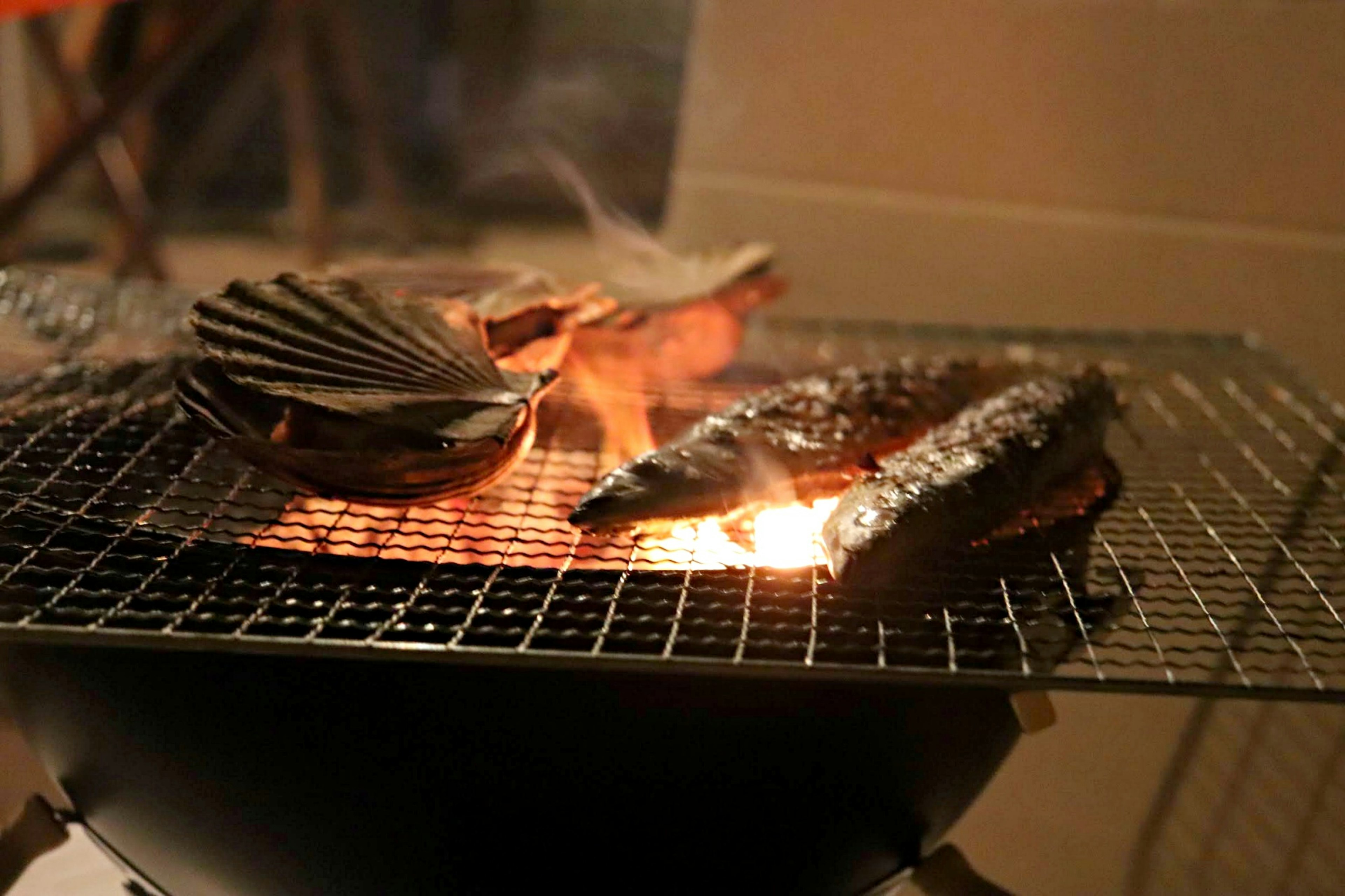 Image of shellfish and fish grilling on a barbecue