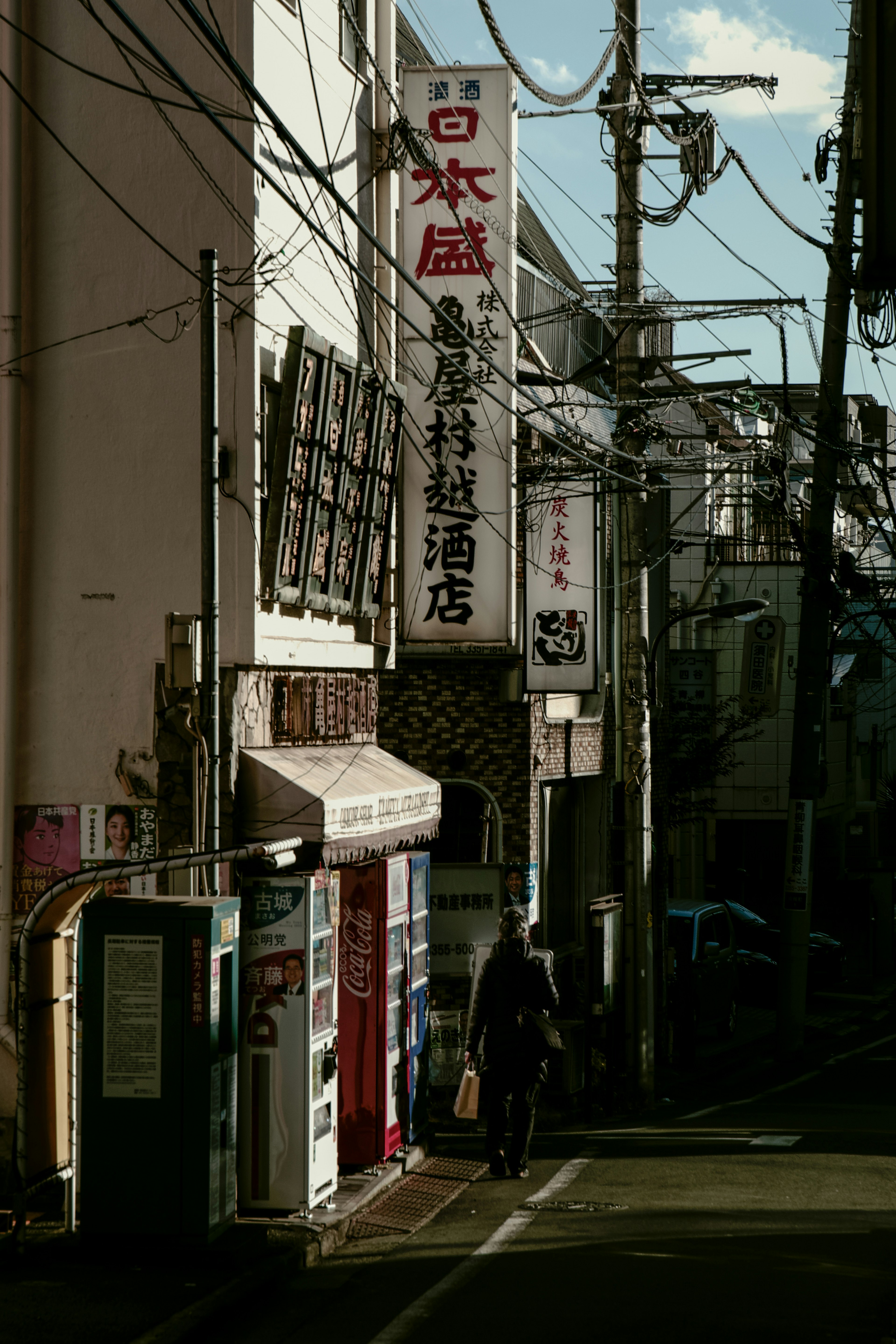 Jalan sempit dengan toko dan papan nama Jepang